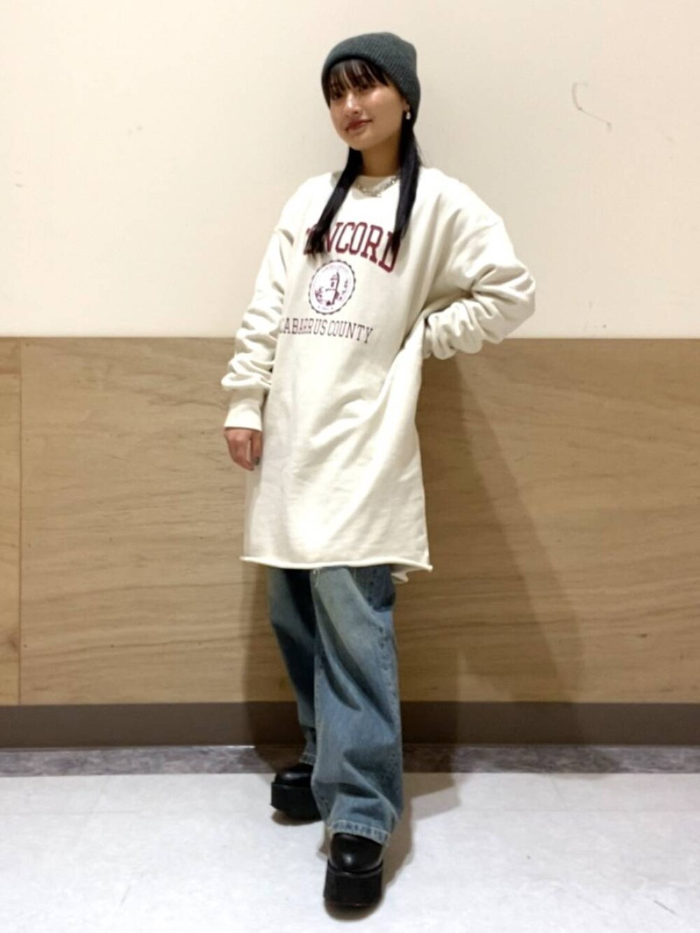 ブルー系のデニムパンツ、ホワイト系のワンピース、シルバー系のネックレスを着用したレディースの冬コーディネートの3枚目の写真