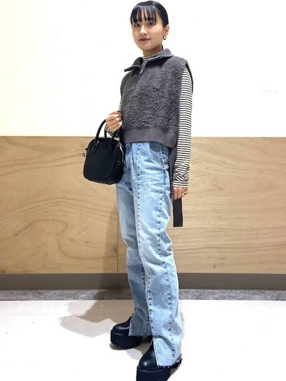 ホワイト系のTシャツ/カットソー、ブルー系のデニムパンツ、ブラック系のボストンバッグを着用したレディースの冬コーディネートの3枚目の写真