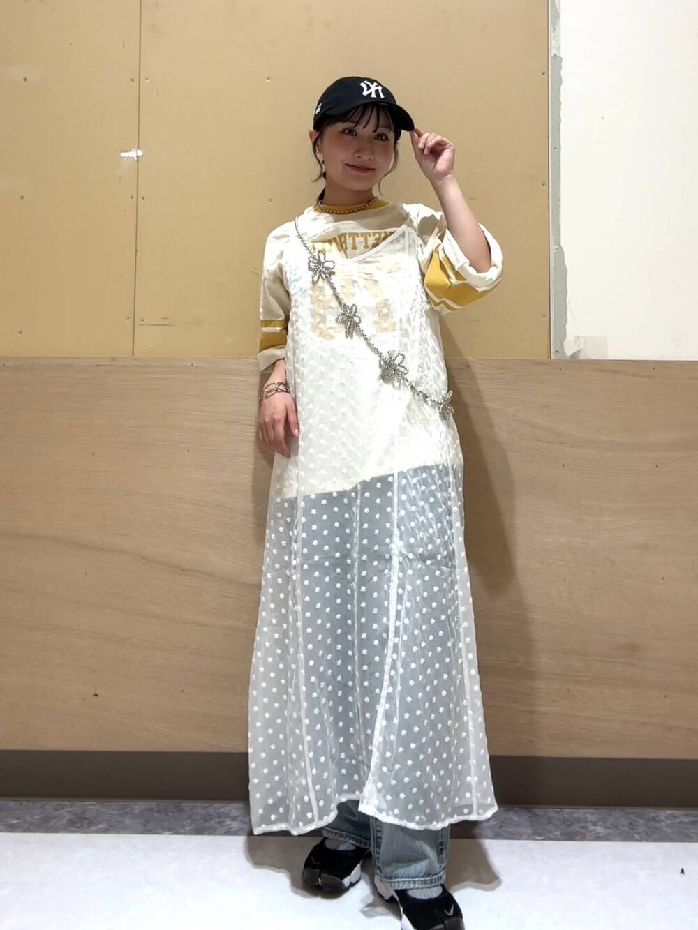 ホワイト系のワンピース、ホワイト系のキャミソール、ブルー系のデニムパンツを着用したレディースの夏コーディネートの3枚目の写真