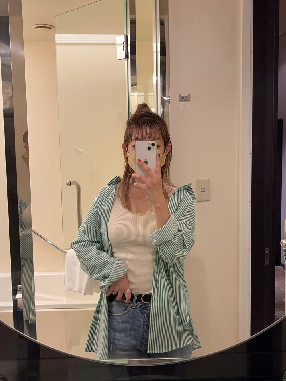 グリーン系のシャツ/ブラウス、ホワイト系のタンクトップ、ブルー系のデニムパンツを着用したレディースの春コーディネートの2枚目の写真