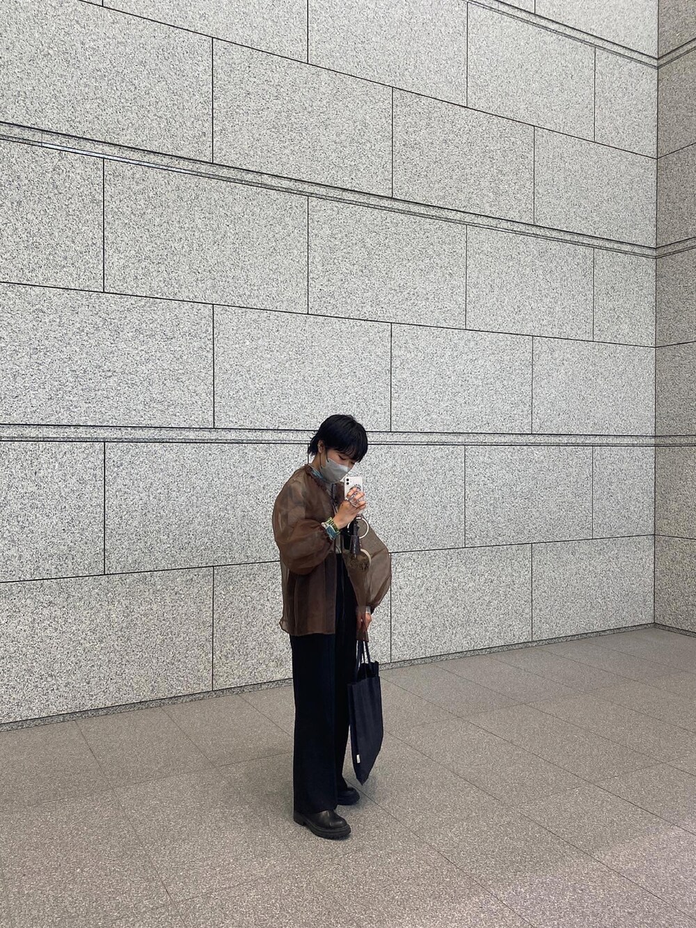 ブラック系のトートバッグ、ブラウン系のシャツ/ブラウス、ブルー系のTシャツ/カットソーを着用したレディースの秋コーディネートの2枚目の写真