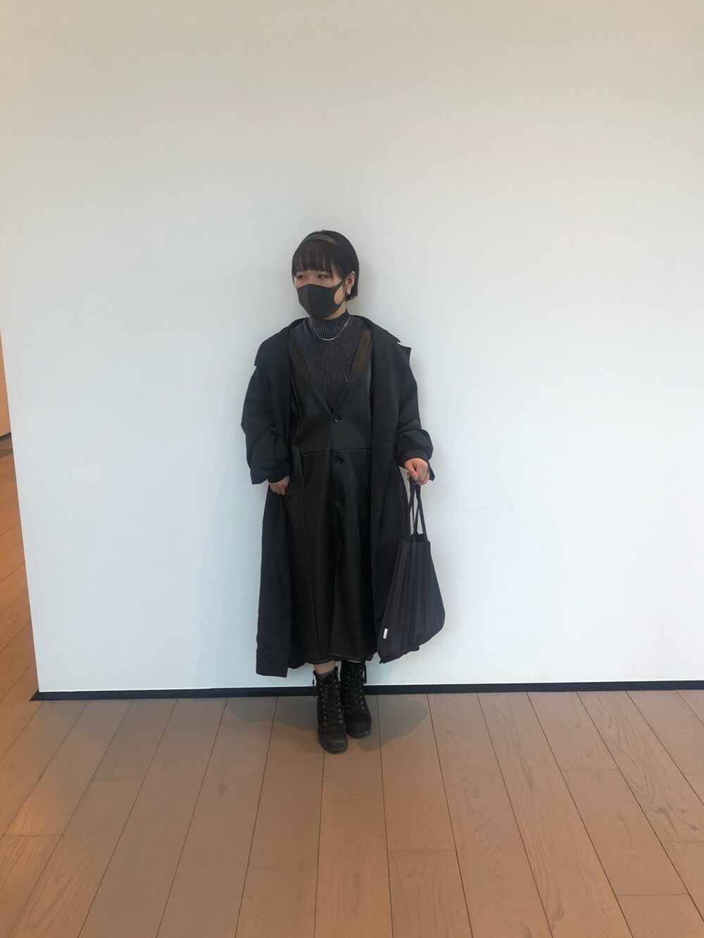 ブラック系のトートバッグ、ブラック系のブーツ、ブルー系のニット/セーターを着用したレディースの冬コーディネートの2枚目の写真