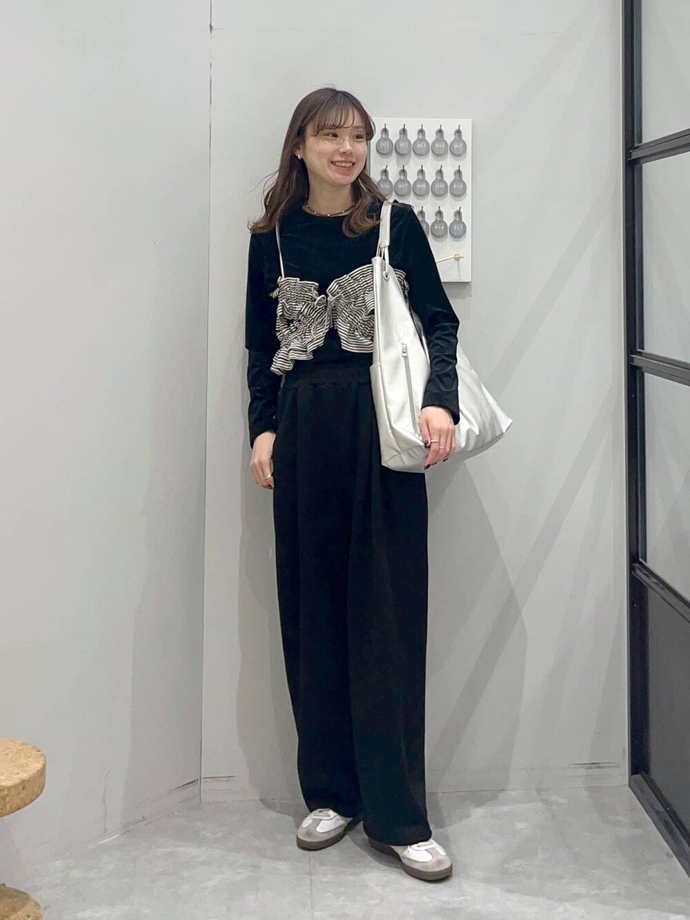 ホワイト系のその他トップス、シルバー系のショルダーバッグ、ブラック系のTシャツ/カットソーを着用したレディースの冬コーディネートの2枚目の写真