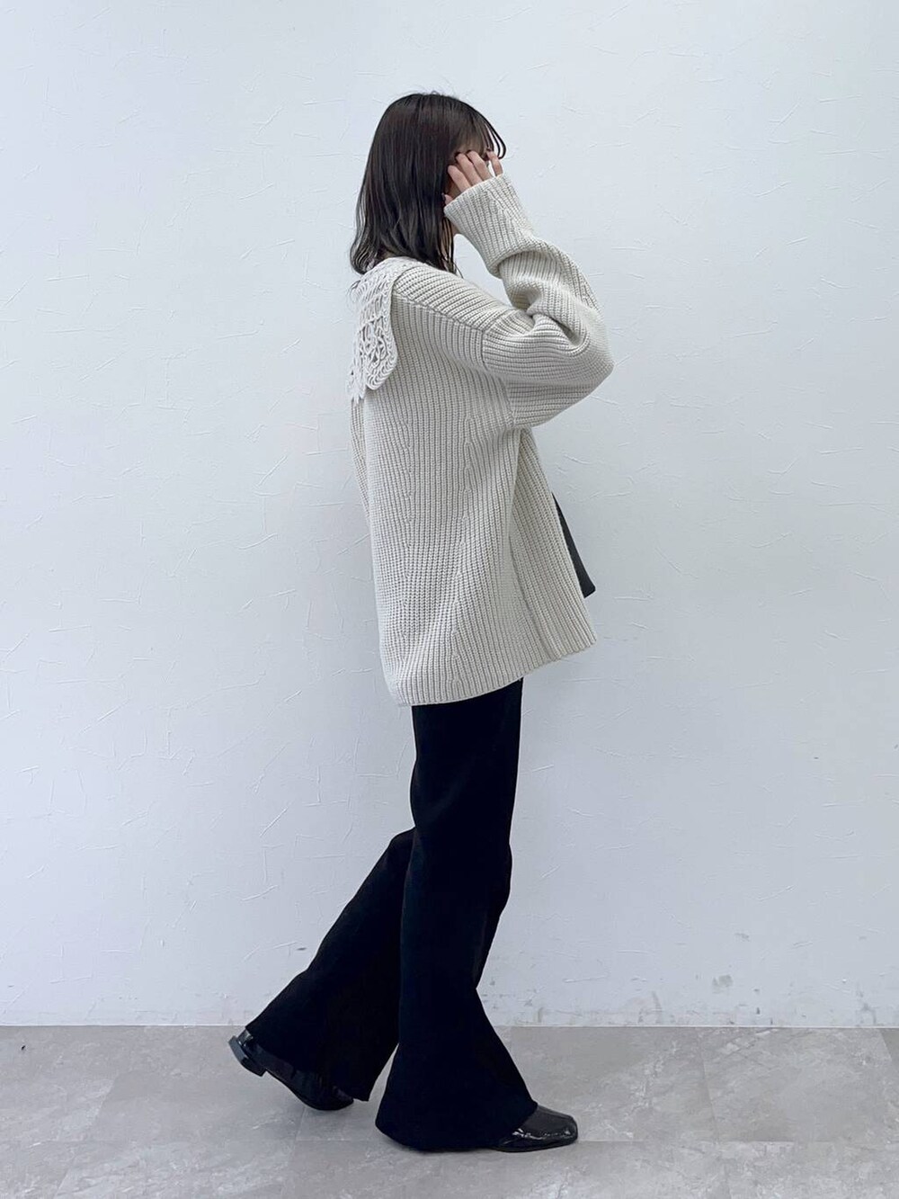 ホワイト系のニット/セーター、ブラック系のショルダーバッグを着用したレディースの秋コーディネートの3枚目の写真