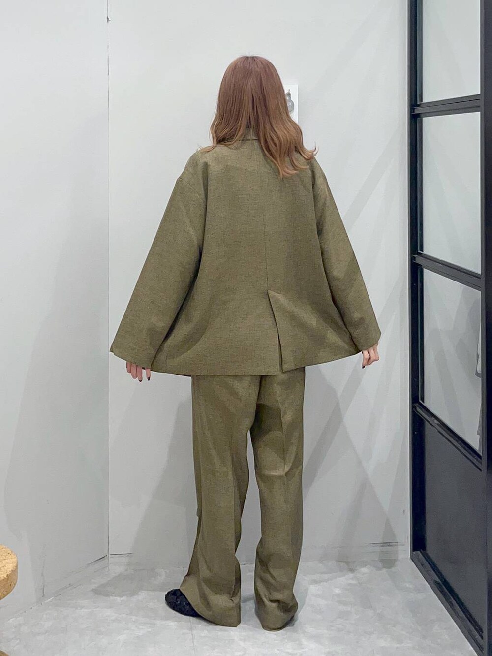 ブラウン系のテーラードジャケット、ブラック系のバレエシューズ、ベージュ系のベストを着用したレディースの秋コーディネートの4枚目の写真