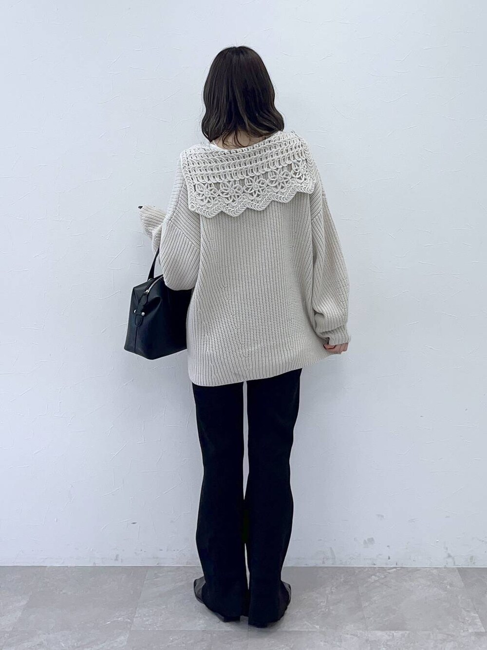 ホワイト系のニット/セーター、ブラック系のショルダーバッグを着用したレディースの秋コーディネートの4枚目の写真