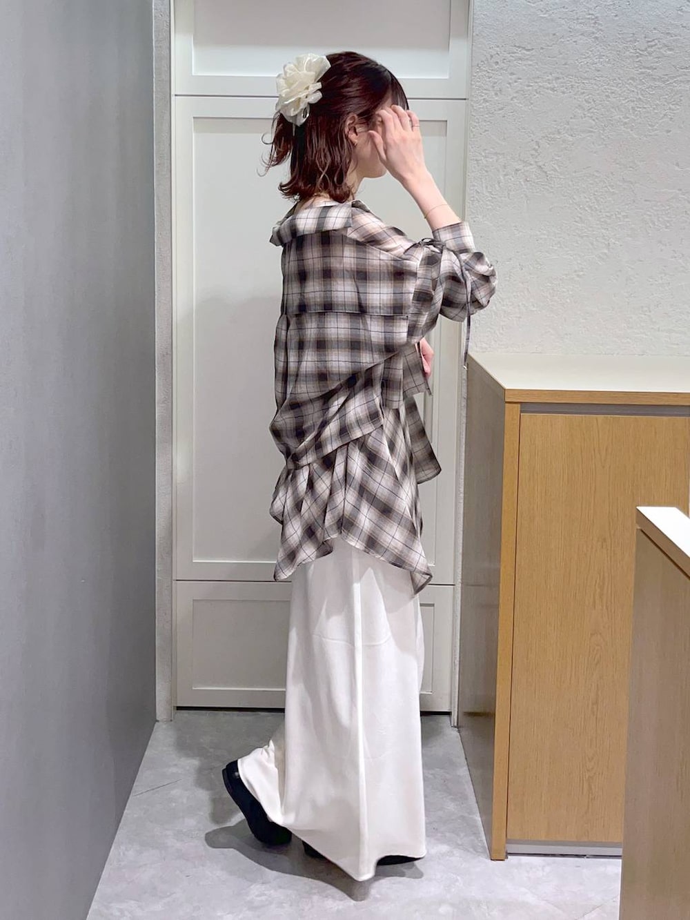 ホワイト系のスカート、ブラウン系のショルダーバッグ、ブラウン系のその他トップスを着用したレディースの春コーディネートの2枚目の写真