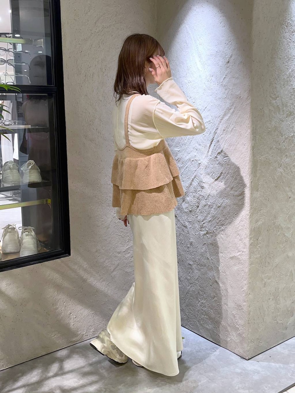 ホワイト系のスカート、ベージュ系のベスト、ホワイト系のTシャツ/カットソーを着用したレディースの秋コーディネートの2枚目の写真