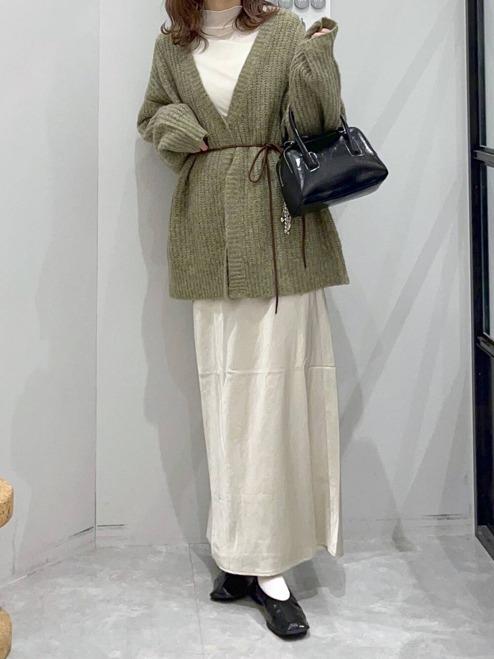 ホワイト系のスカート、ブラック系のボストンバッグ、ホワイト系のTシャツ/カットソーを着用したレディースの秋コーディネートの2枚目の写真