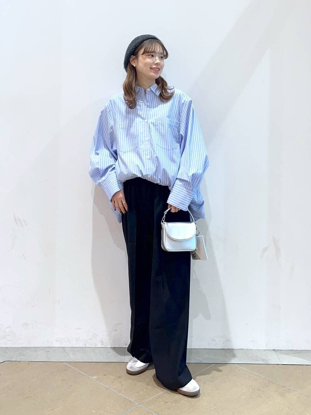 ブラック系のスラックス、ブルー系のシャツ/ブラウス、シルバー系のショルダーバッグを着用したレディースの冬コーディネートの2枚目の写真