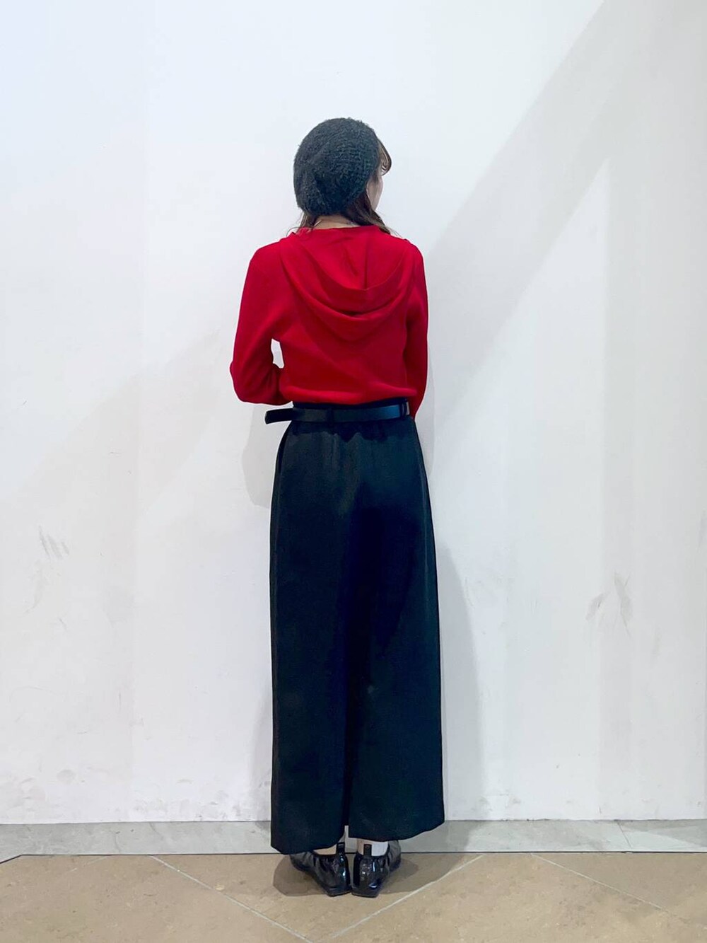 ブラック系のスカート、レッド系のニット/セーター、グレー系のハンチング/ベレー帽を着用したレディースの冬コーディネートの3枚目の写真