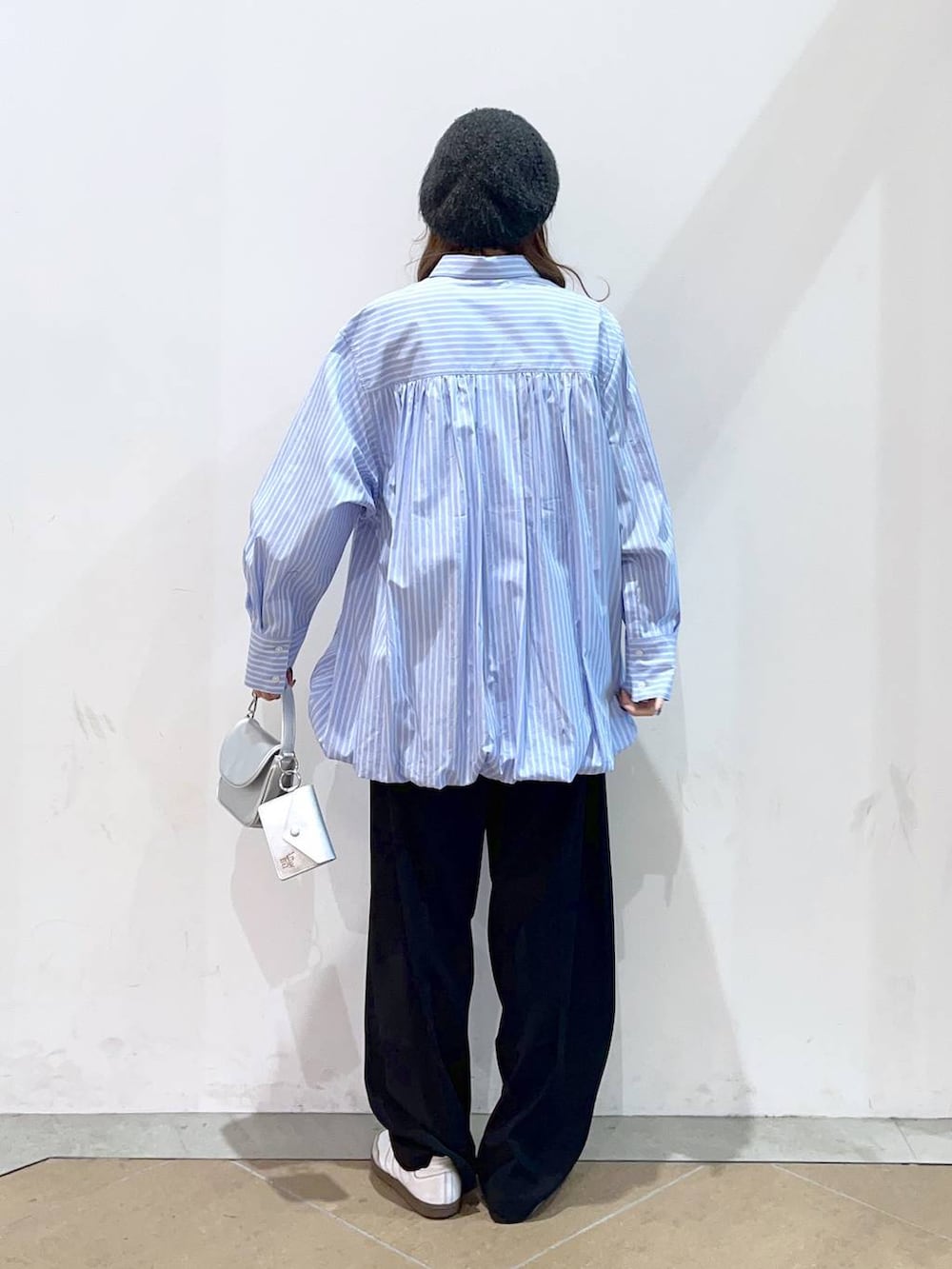 ブラック系のスラックス、ブルー系のシャツ/ブラウス、シルバー系のショルダーバッグを着用したレディースの冬コーディネートの4枚目の写真