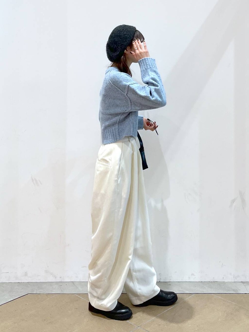 ブラック系のブーツ、ブルー系のニット/セーター、ホワイト系のその他パンツを着用したレディースの秋コーディネートの4枚目の写真