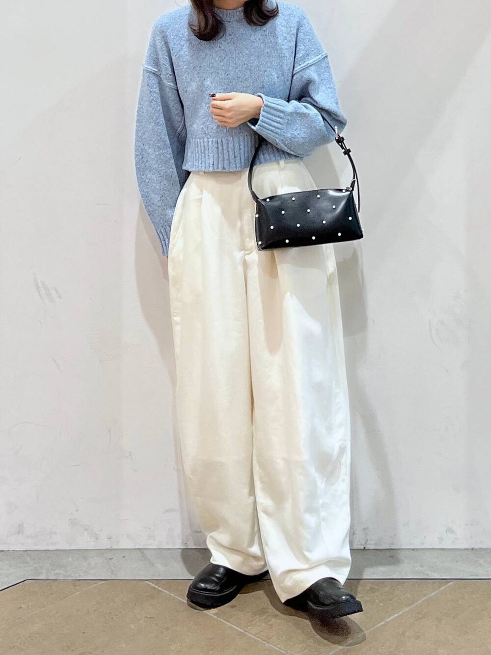 ブラック系のブーツ、ブルー系のニット/セーター、ホワイト系のその他パンツを着用したレディースの秋コーディネートの2枚目の写真