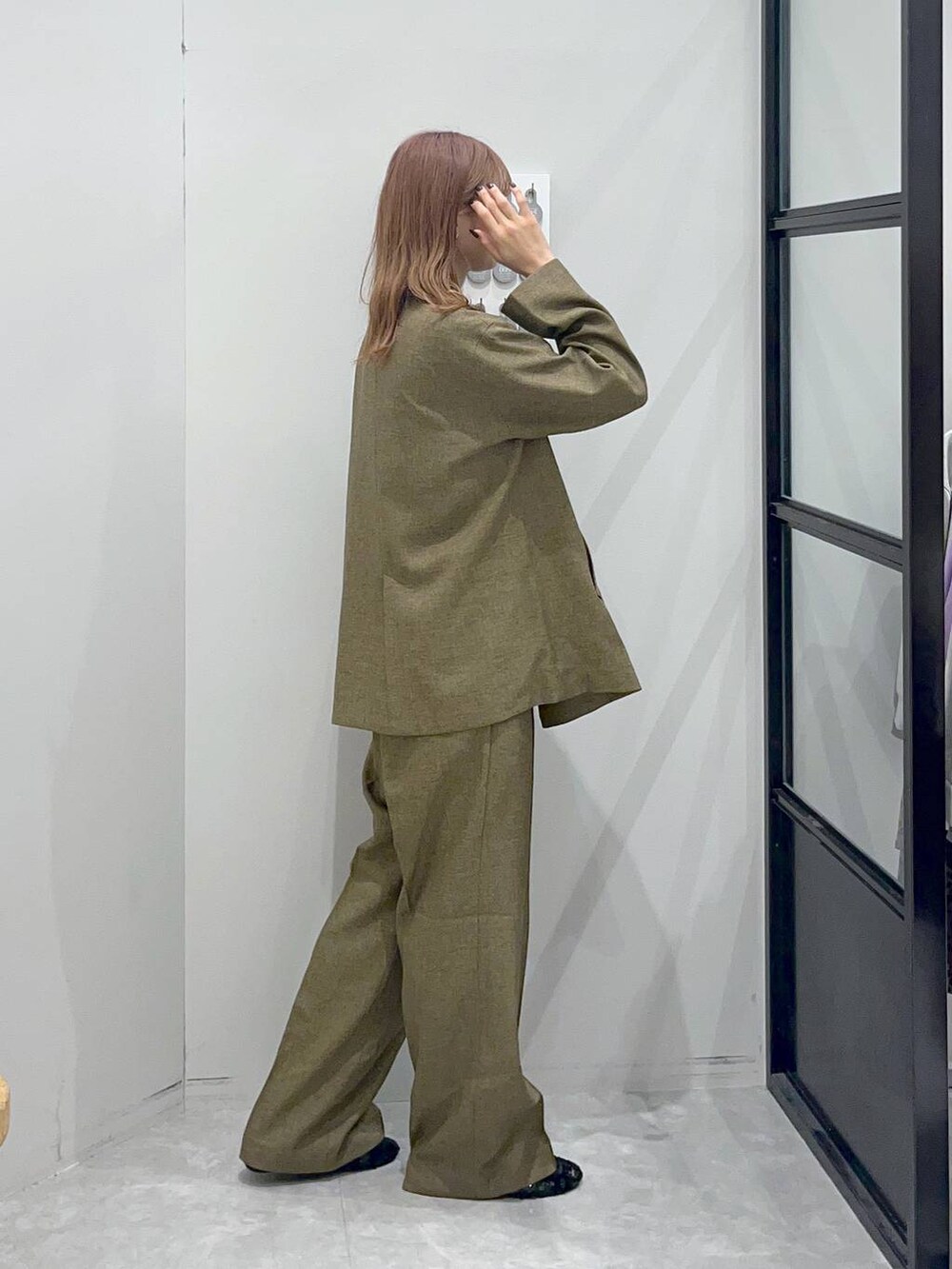 ブラウン系のテーラードジャケット、ブラック系のバレエシューズ、ベージュ系のベストを着用したレディースの秋コーディネートの3枚目の写真