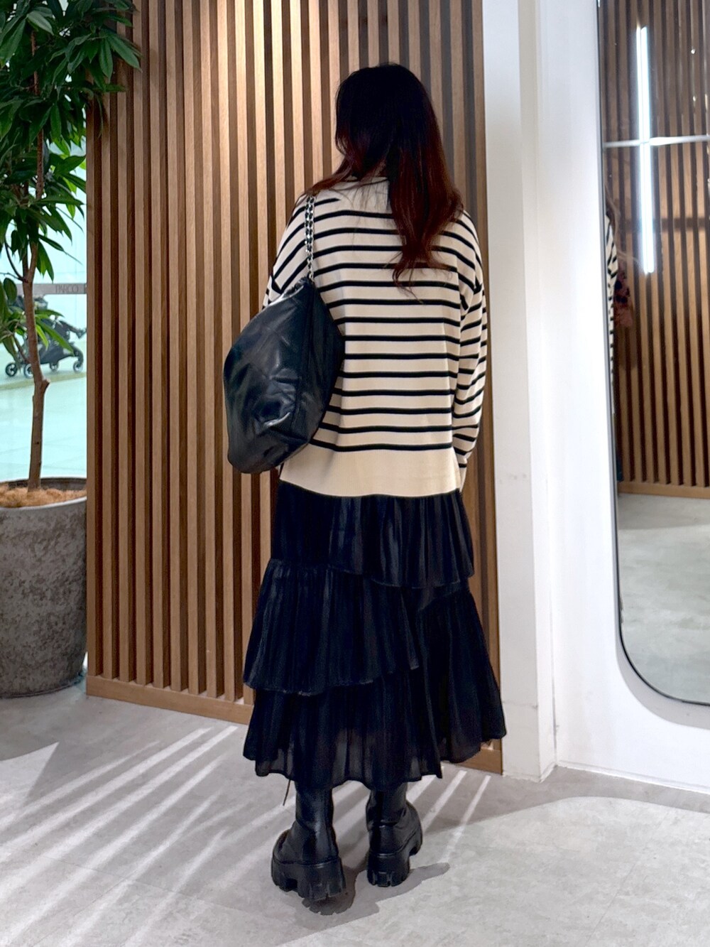 ベージュ系のニット/セーター、ブラック系のスカート、ブラック系のマフラーを着用したレディースの冬コーディネートの2枚目の写真