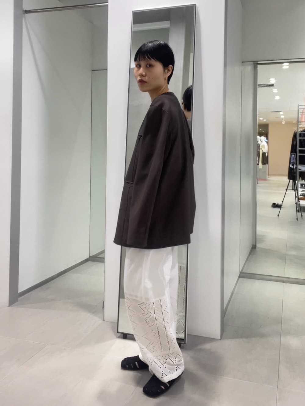 ブラック系のサンダル、ホワイト系のその他パンツ、ブラウン系のノーカラージャケットを着用したレディースの春コーディネートの3枚目の写真