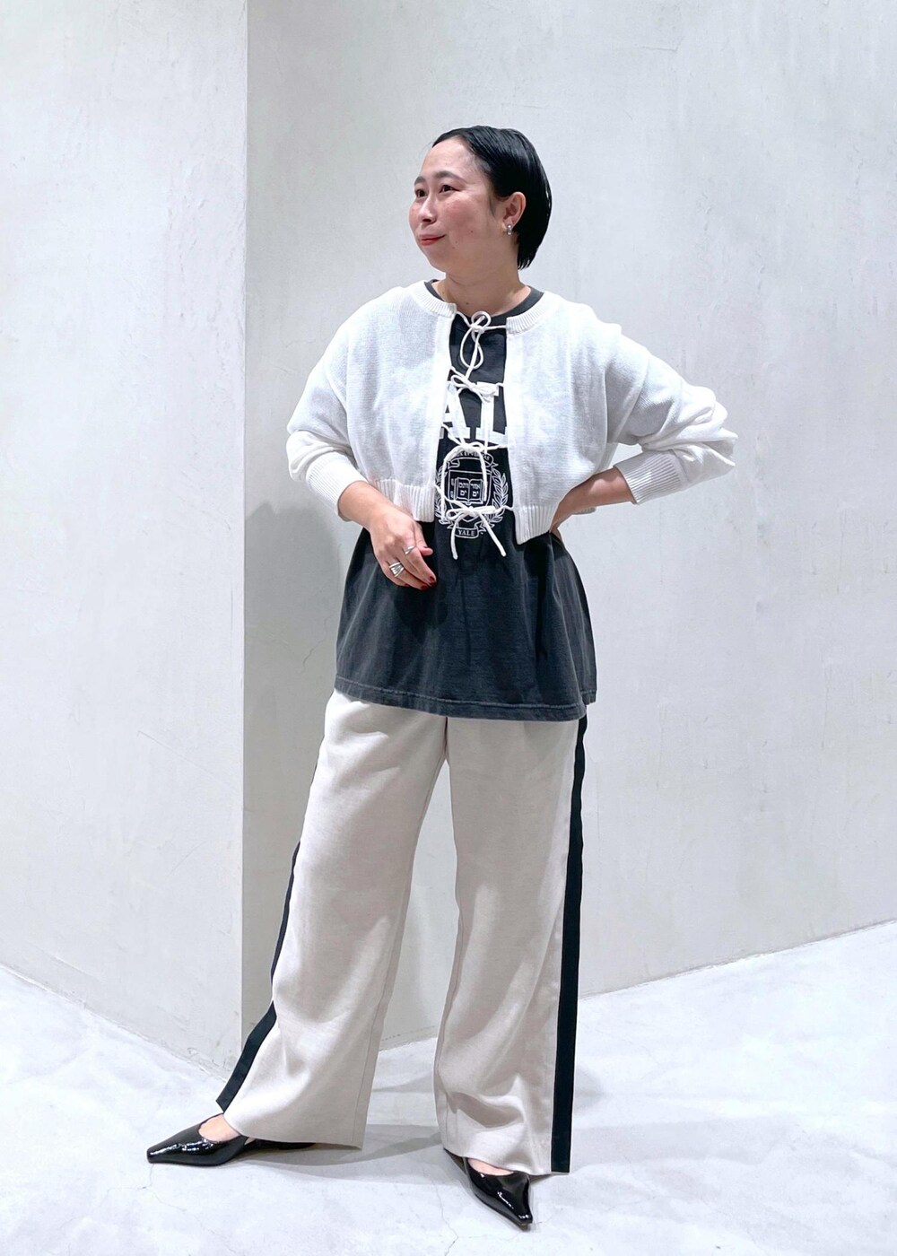 ブラック系のその他シューズ、ブラック系のTシャツ/カットソー、ホワイト系のニット/セーターを着用したレディースの春コーディネートの3枚目の写真