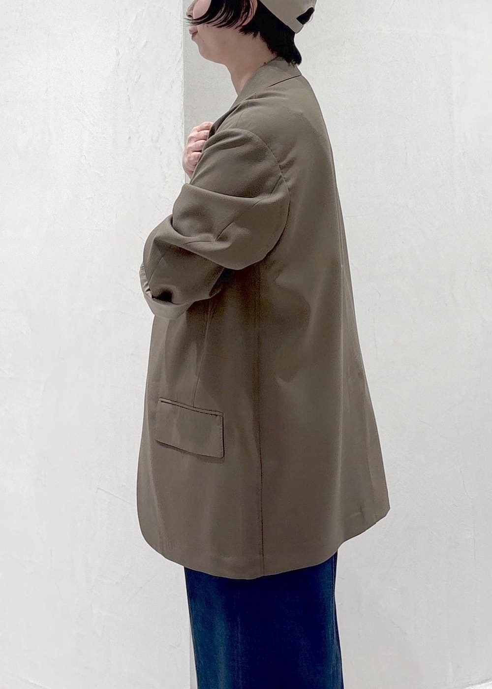 ブラウン系のパンプス、ホワイト系のキャミソール、ブルー系のデニムパンツを着用したレディースの冬コーディネートの8枚目の写真