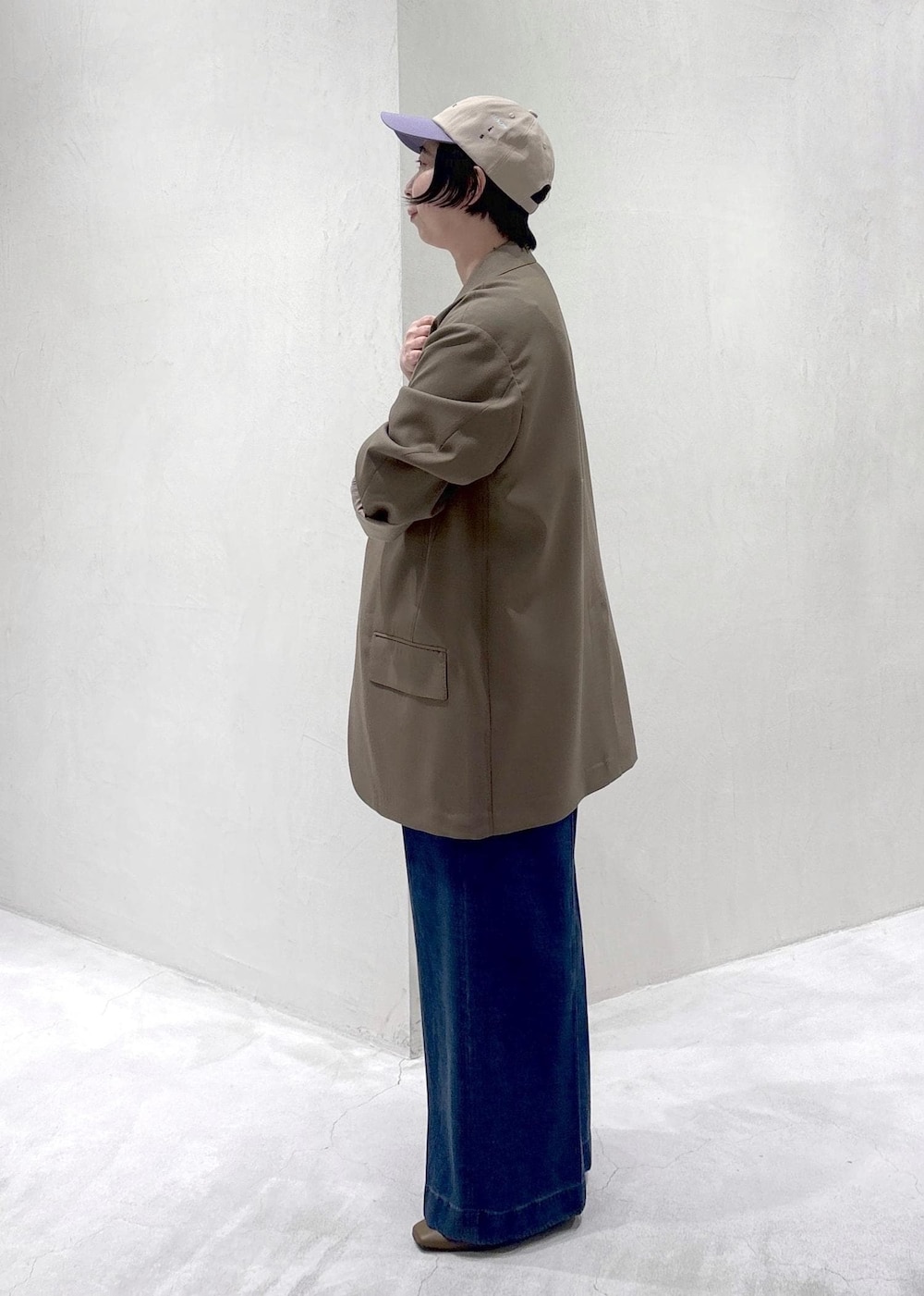 ブラウン系のパンプス、ホワイト系のキャミソール、ブルー系のデニムパンツを着用したレディースの冬コーディネートの5枚目の写真