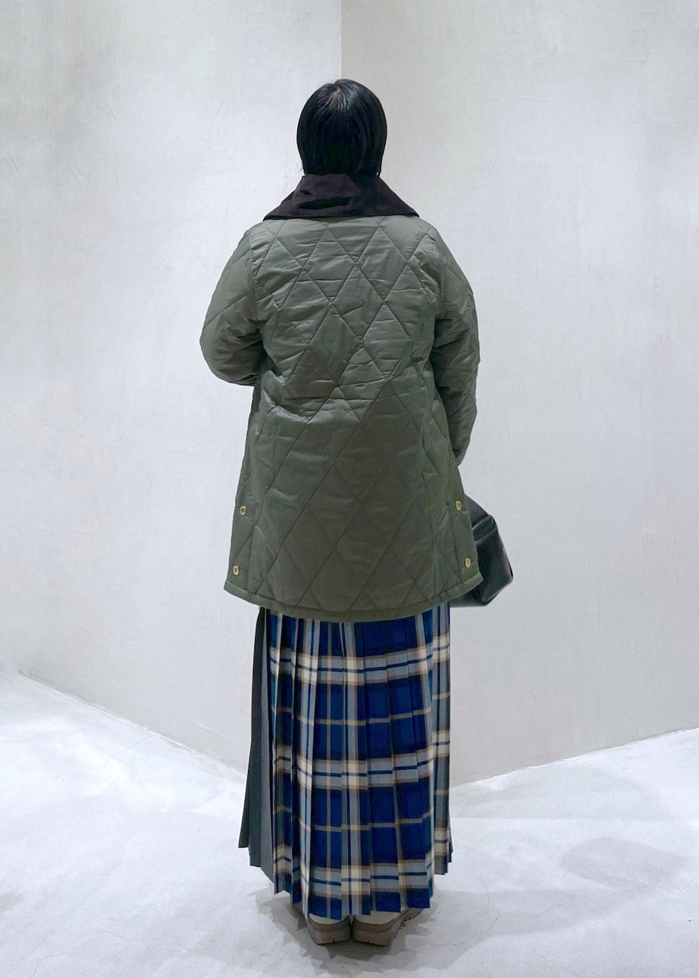 ブラック系のハンドバッグ、グリーン系のスカート、ホワイト系のTシャツ/カットソーを着用したレディースの秋コーディネートの3枚目の写真