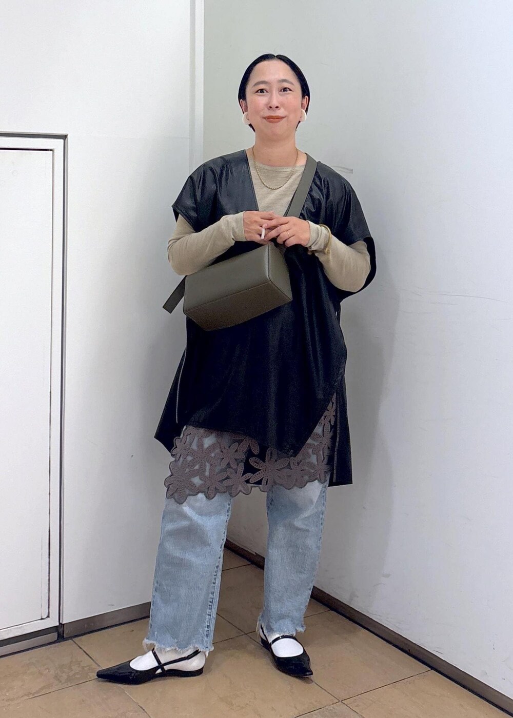 グリーン系のショルダーバッグ、グレー系のスカート、ゴールド系のTシャツ/カットソーを着用したレディースの秋コーディネートの2枚目の写真