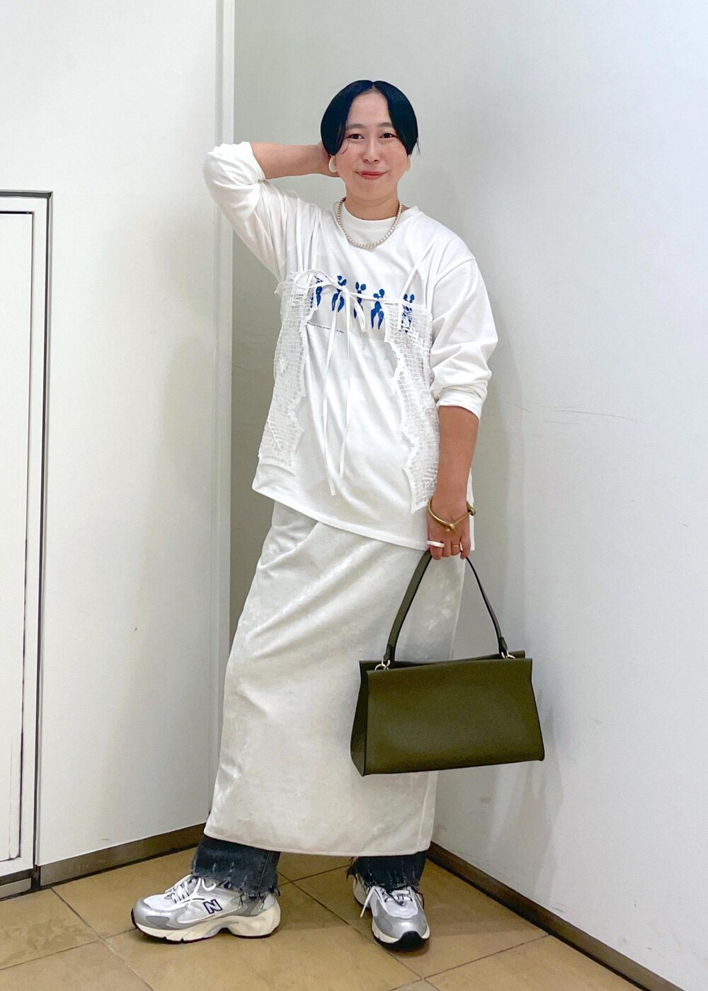 ホワイト系のスカート、ブラック系のデニムパンツを着用したレディースの夏コーディネートの4枚目の写真