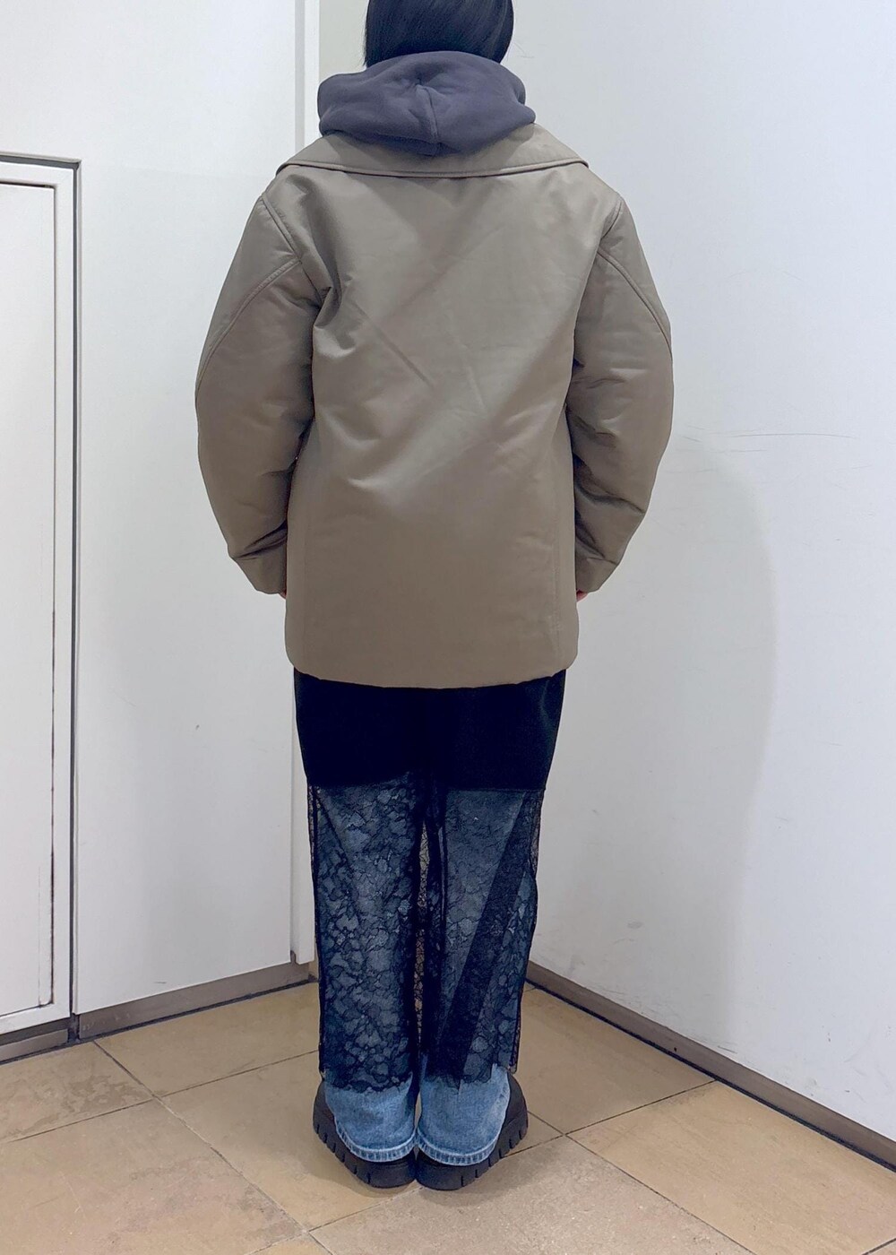 グレー系のパーカー、グリーン系のダウンジャケット/コート、ブラック系のボストンバッグを着用したレディースの冬コーディネートの8枚目の写真