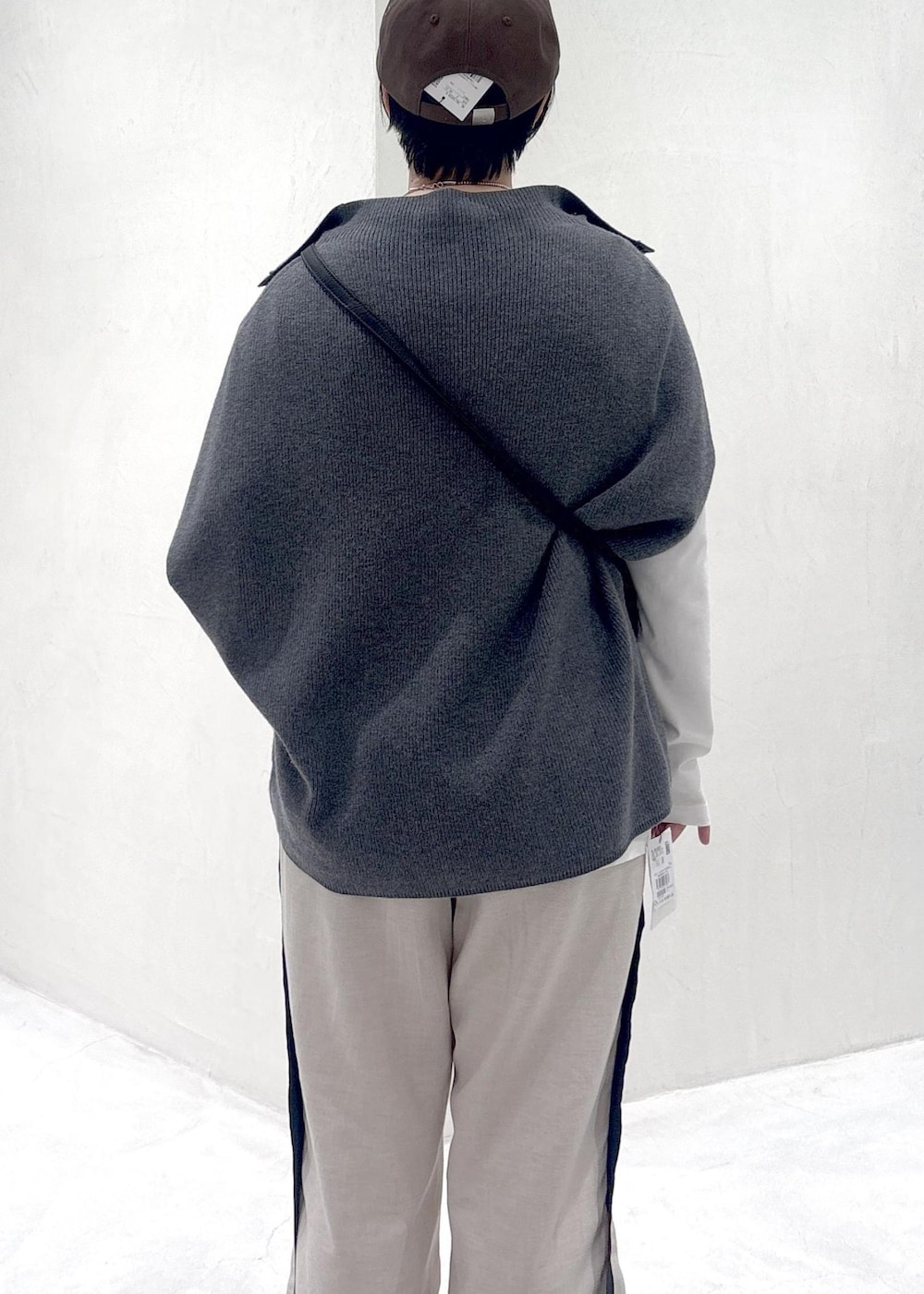 グレー系のニット/セーター、ブラック系のその他シューズ、ホワイト系のTシャツ/カットソーを着用したレディースの冬コーディネートの6枚目の写真