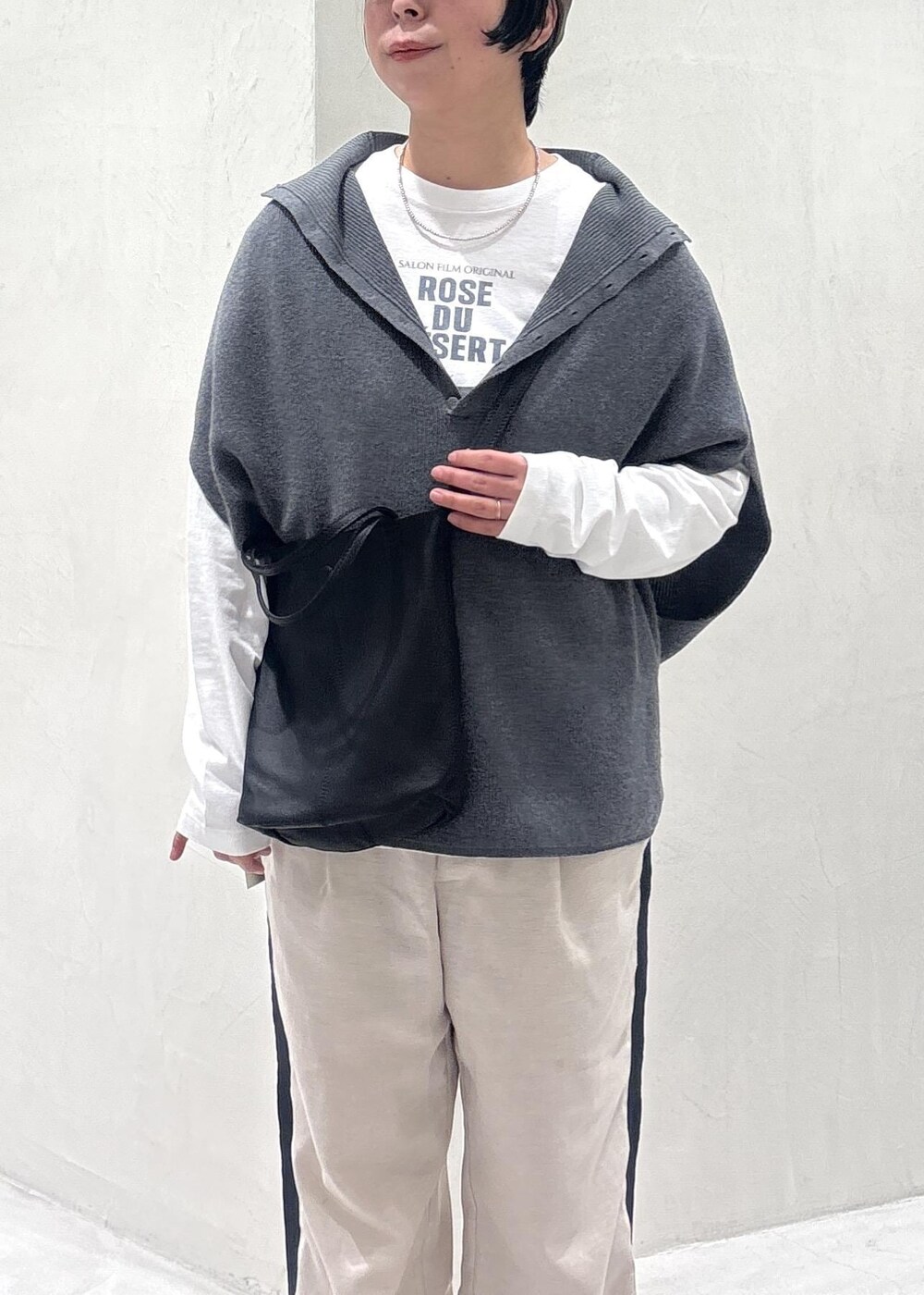 グレー系のニット/セーター、ブラック系のその他シューズ、ホワイト系のTシャツ/カットソーを着用したレディースの冬コーディネートの5枚目の写真