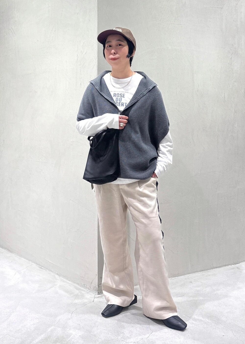 グレー系のニット/セーター、ブラック系のその他シューズ、ホワイト系のTシャツ/カットソーを着用したレディースの冬コーディネートの2枚目の写真