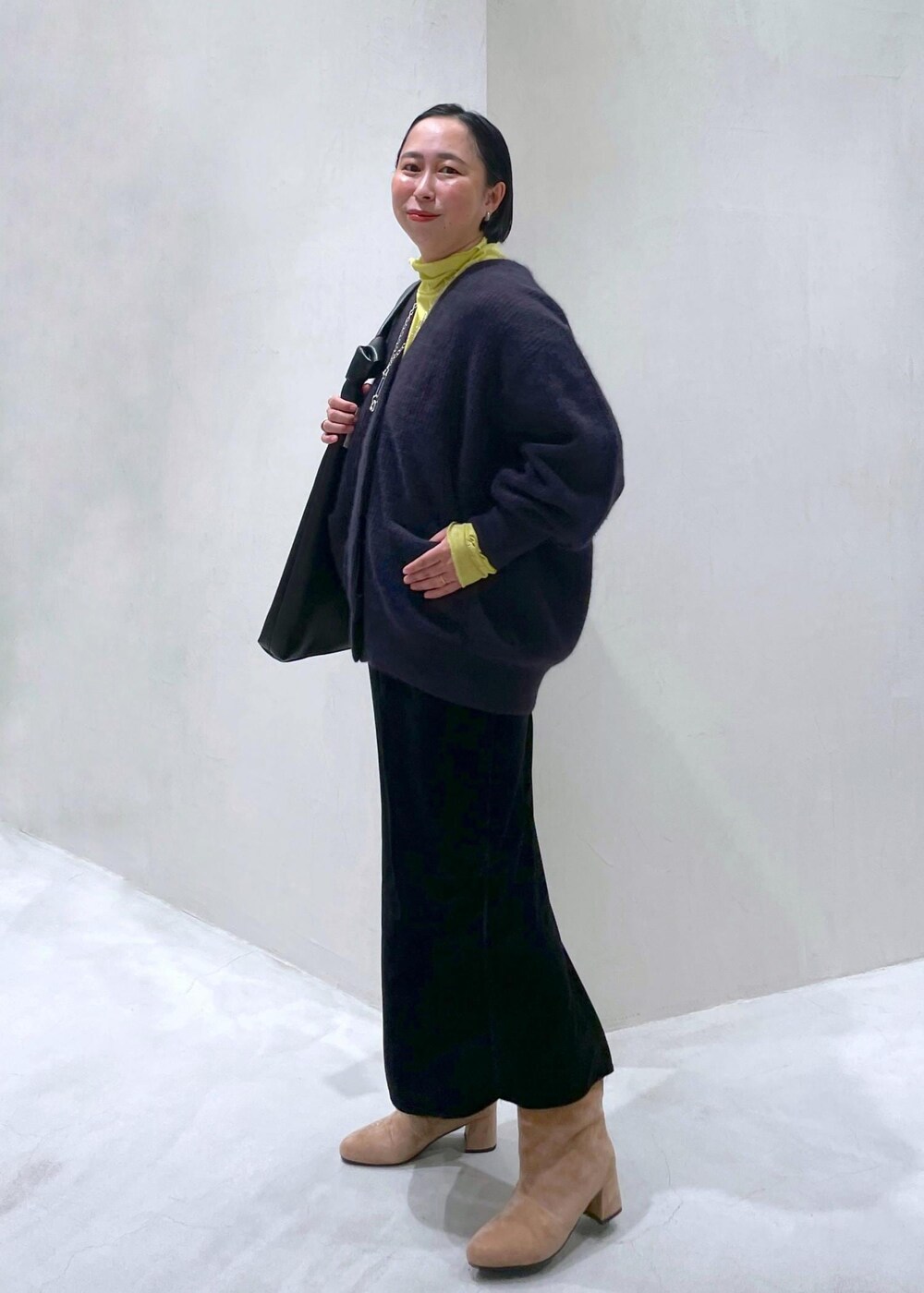 ブラック系のスカート、レッド系のカーディガン/ボレロ、グリーン系のTシャツ/カットソーを着用したレディースの秋コーディネートの2枚目の写真