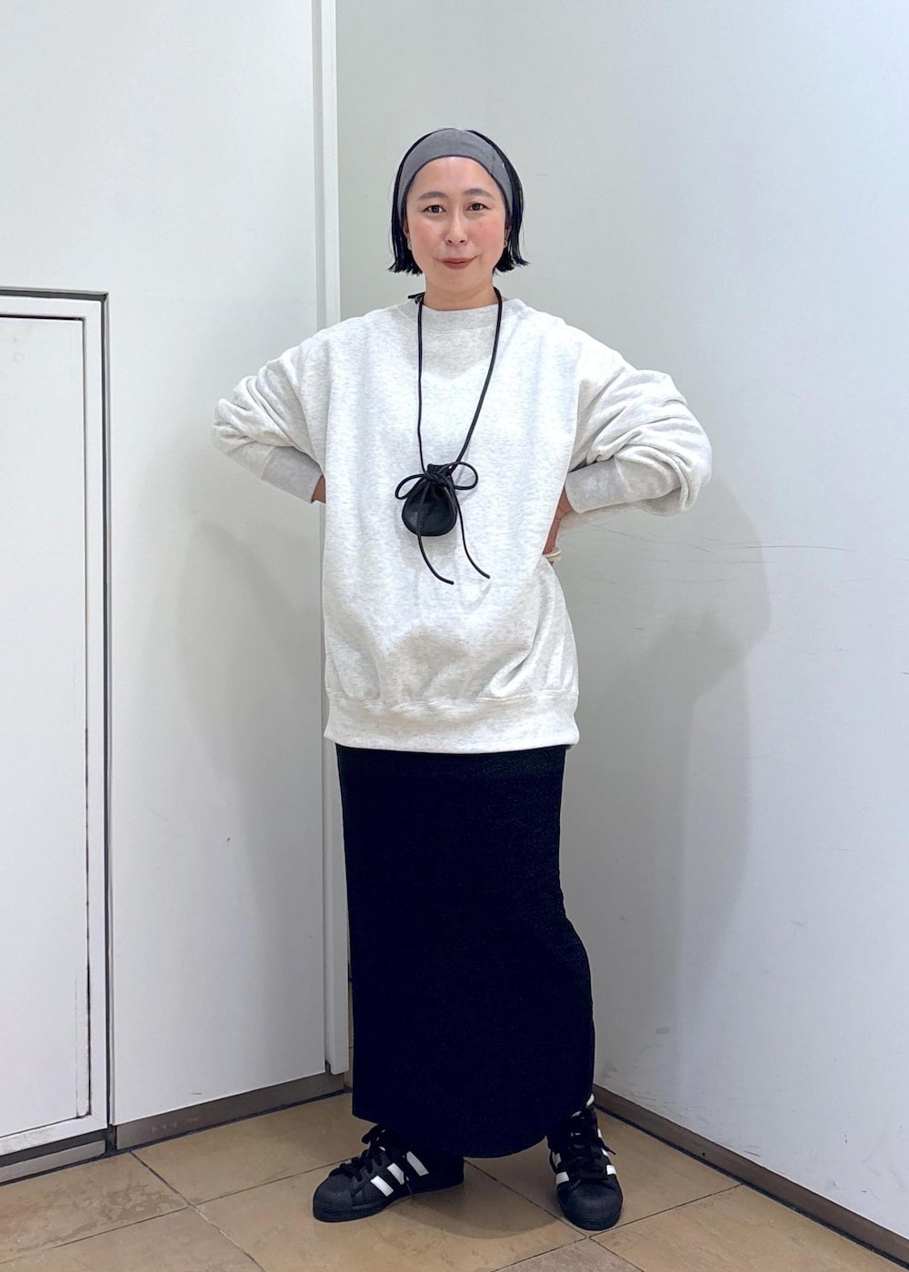 グレー系のスウェット、ブルー系のスカート、グレー系のヘアバンドを着用したレディースの冬コーディネートの4枚目の写真