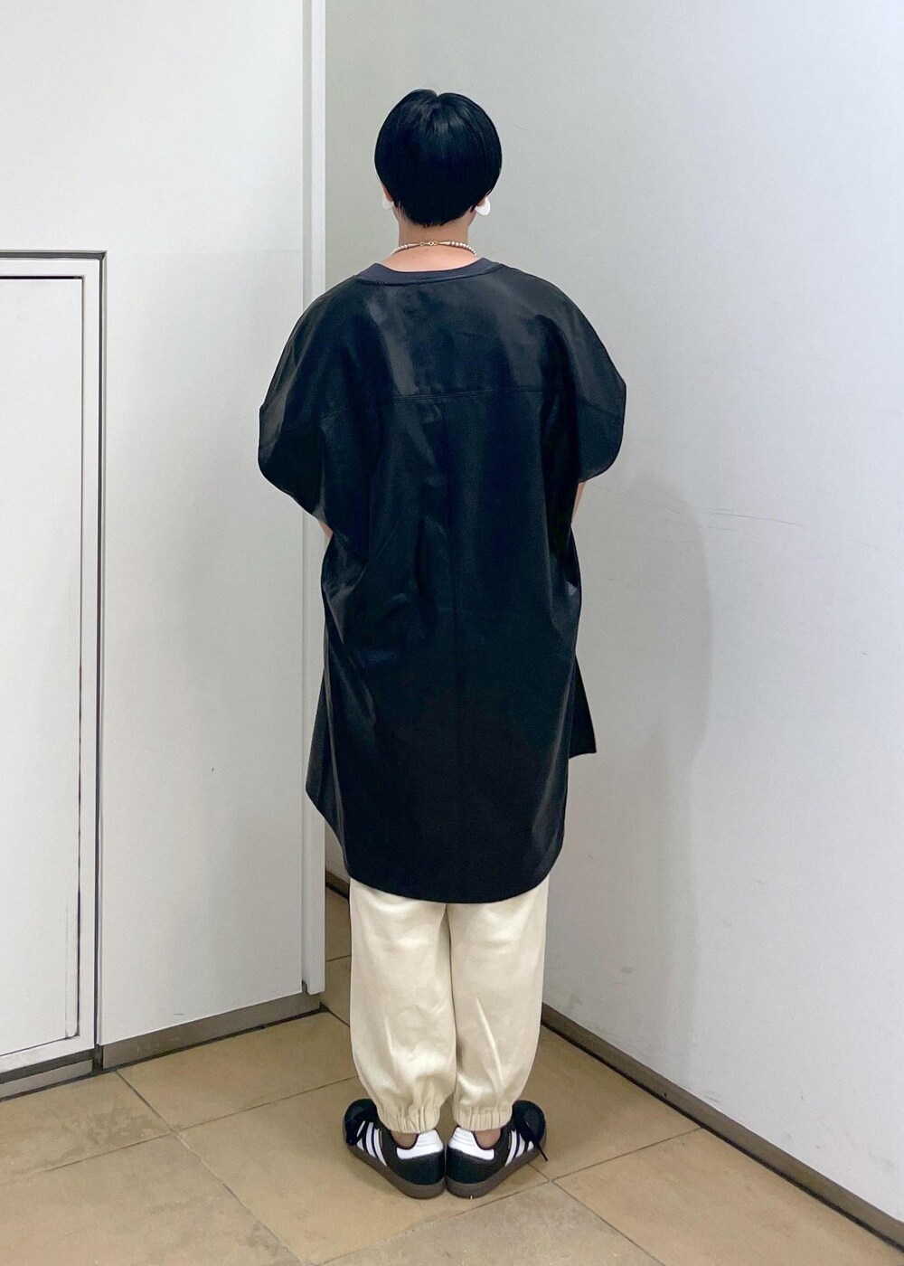 グリーン系のショルダーバッグ、ブラック系のTシャツ/カットソー、ホワイト系のスウェットパンツを着用したレディースの夏コーディネートの7枚目の写真