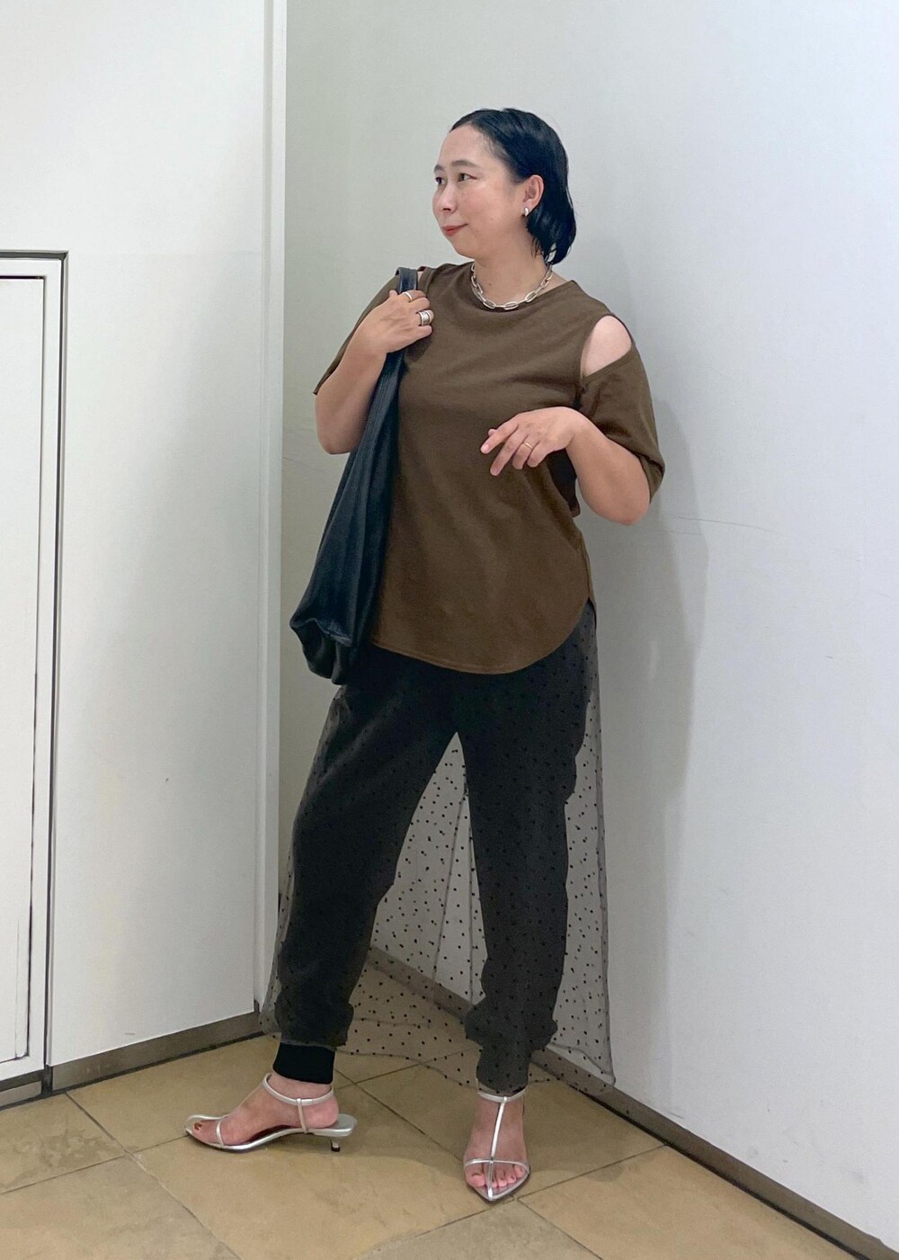 グレー系のその他パンツ、シルバー系のサンダル、ブラウン系のTシャツ/カットソーを着用したレディースの夏コーディネートの2枚目の写真