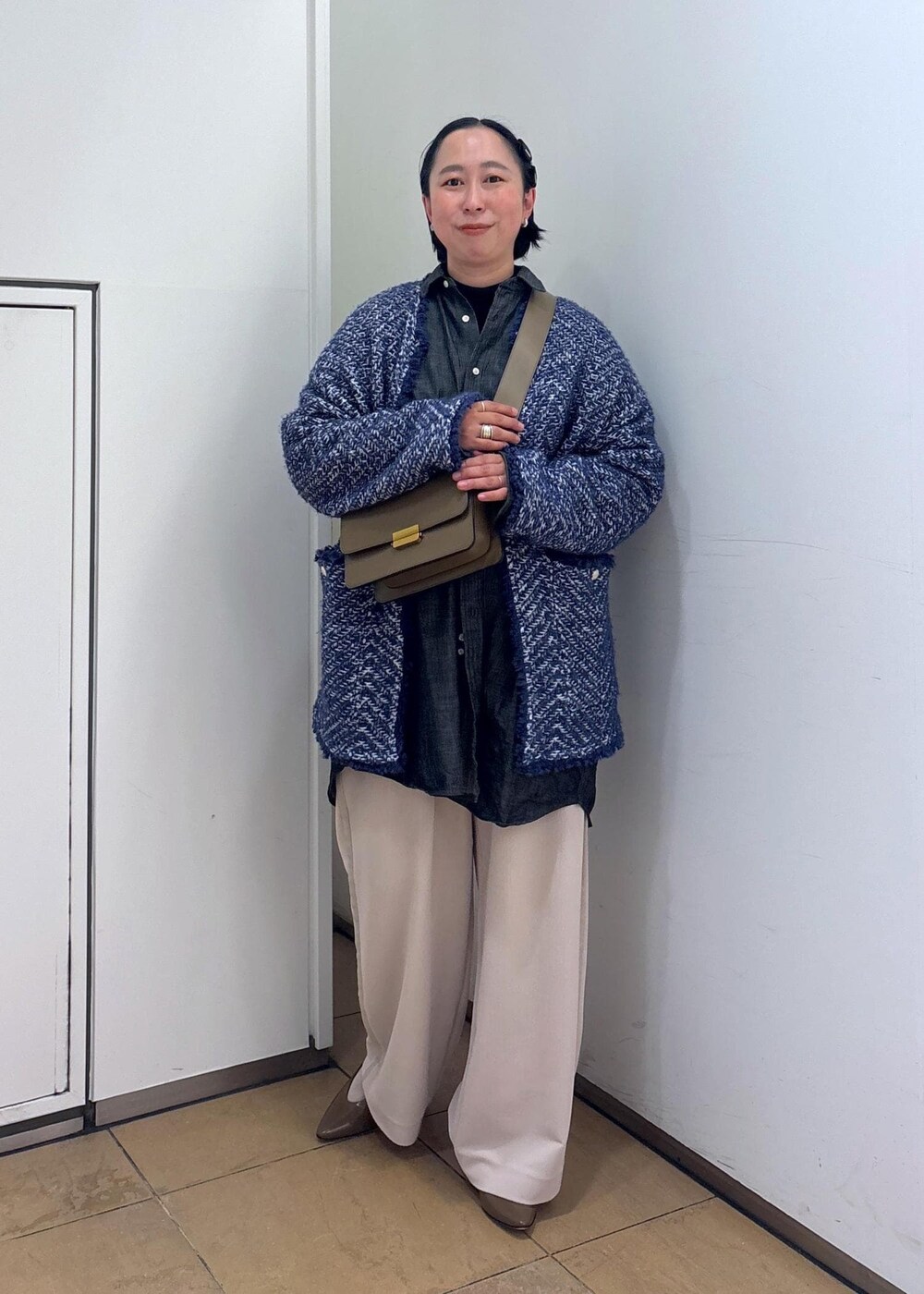 ブルー系のカーディガン/ボレロ、ブラウン系のショルダーバッグ、ホワイト系のその他パンツを着用したレディースの冬コーディネートの3枚目の写真