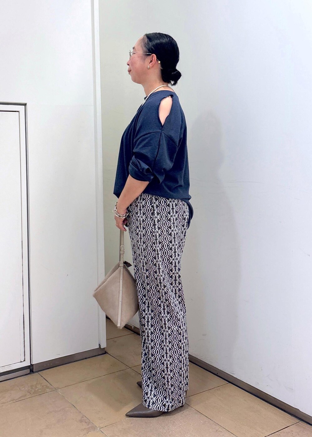 ブラック系のその他パンツ、ベージュ系のショルダーバッグ、グリーン系のパンプスを着用したレディースの夏コーディネートの3枚目の写真