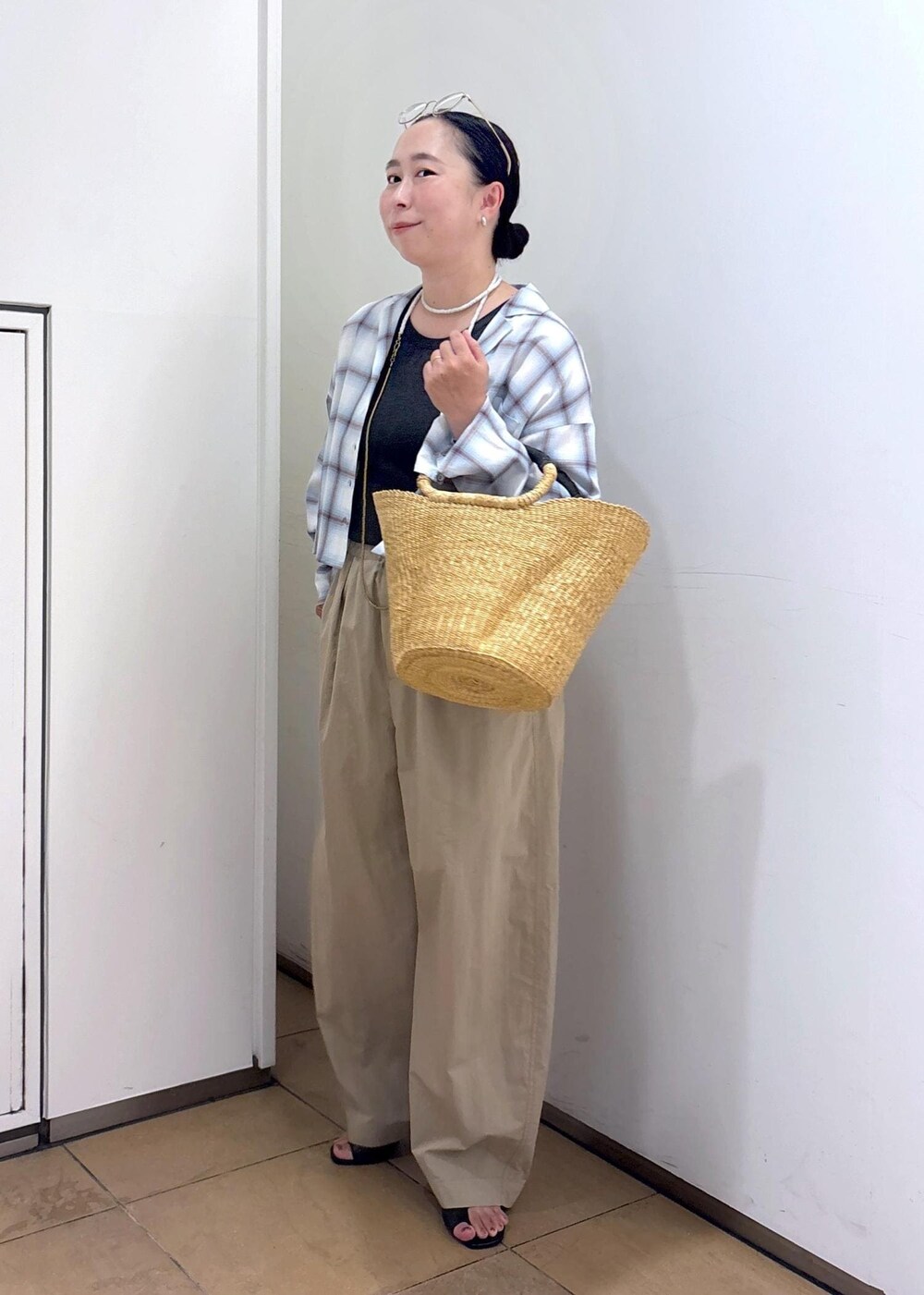 ホワイト系のトートバッグ、ブラック系のサンダル、グレー系のタンクトップを着用したレディースの夏コーディネートの6枚目の写真