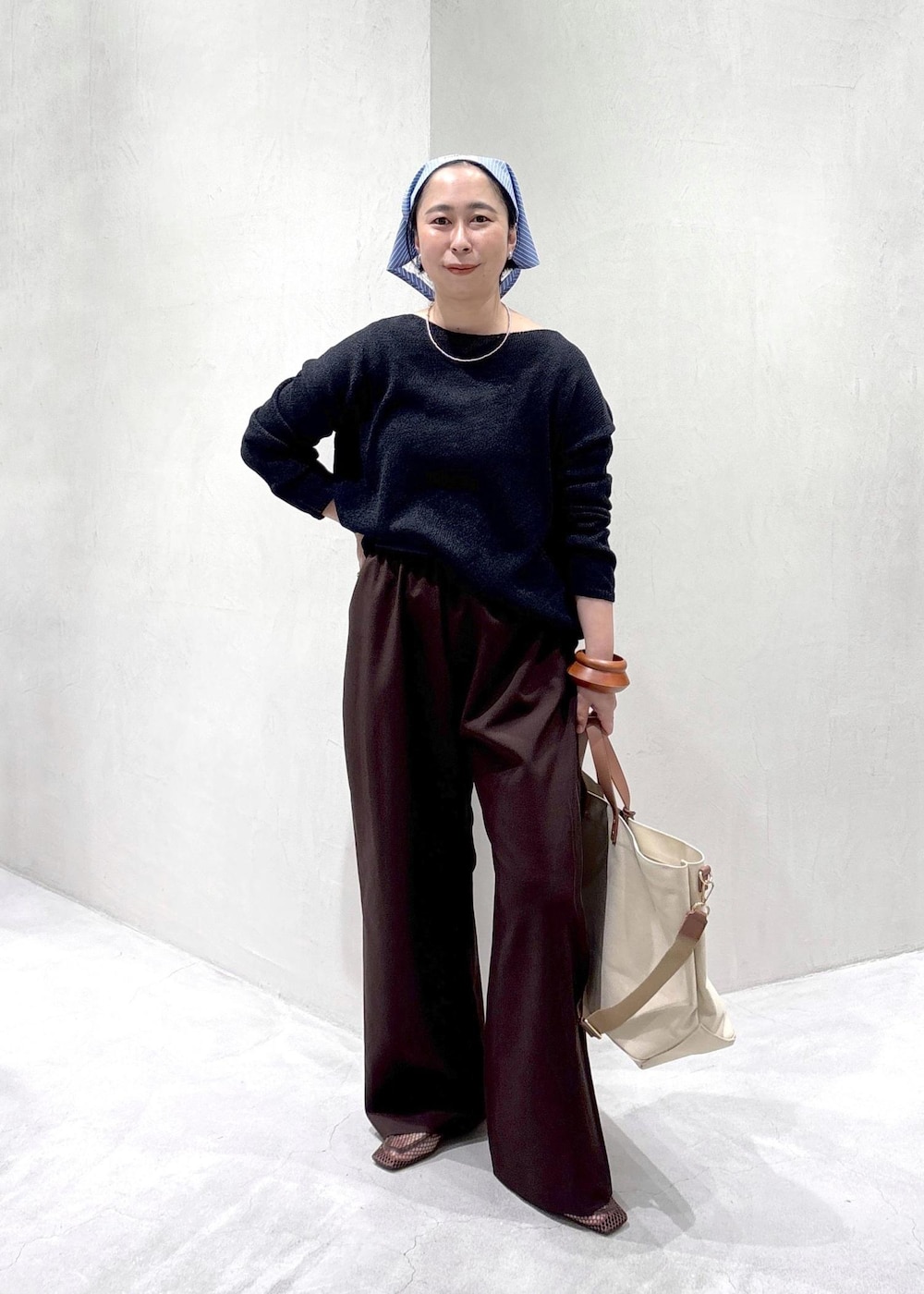 ブラウン系のその他パンツ、ベージュ系のトートバッグ、ブラウン系のローファーを着用したレディースの春コーディネートの3枚目の写真