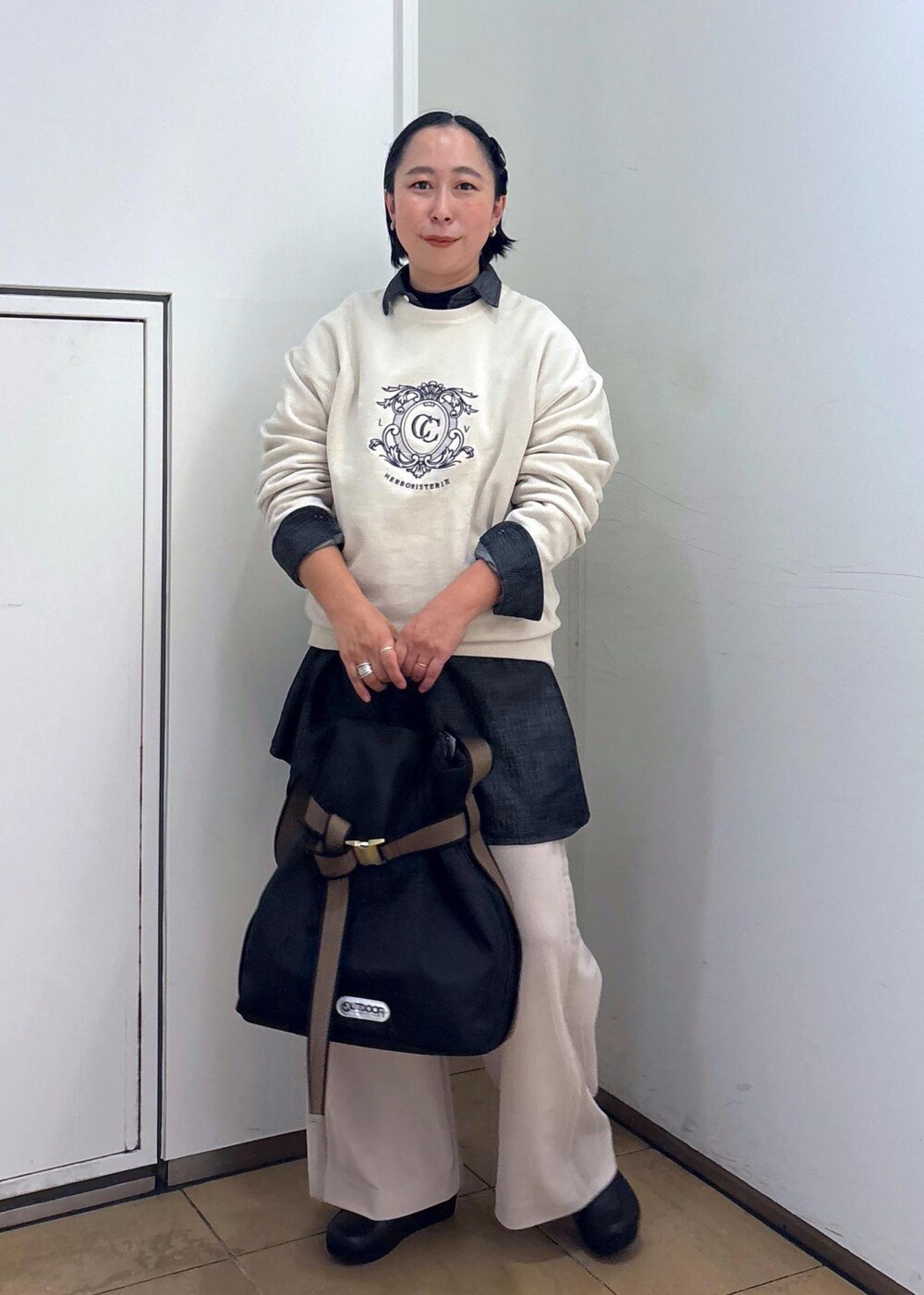 ブラック系のTシャツ/カットソー、ホワイト系のスウェット、ブラック系のトートバッグを着用したレディースの冬コーディネートの2枚目の写真