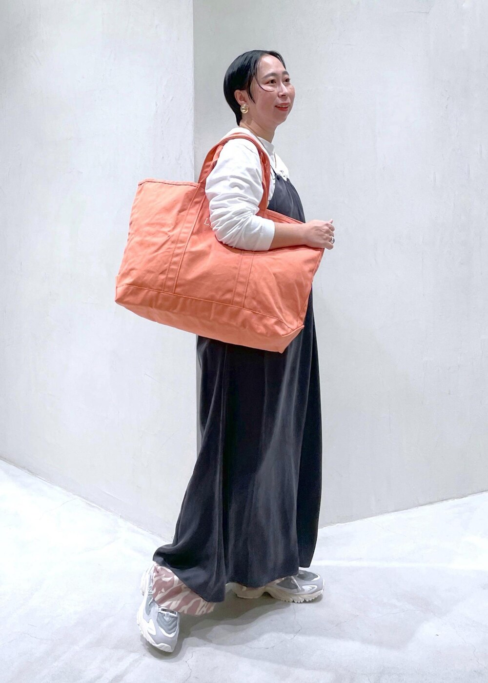 イエロー系のその他パンツ、ホワイト系のTシャツ/カットソー、グレー系のワンピースを着用したレディースの春コーディネートの2枚目の写真