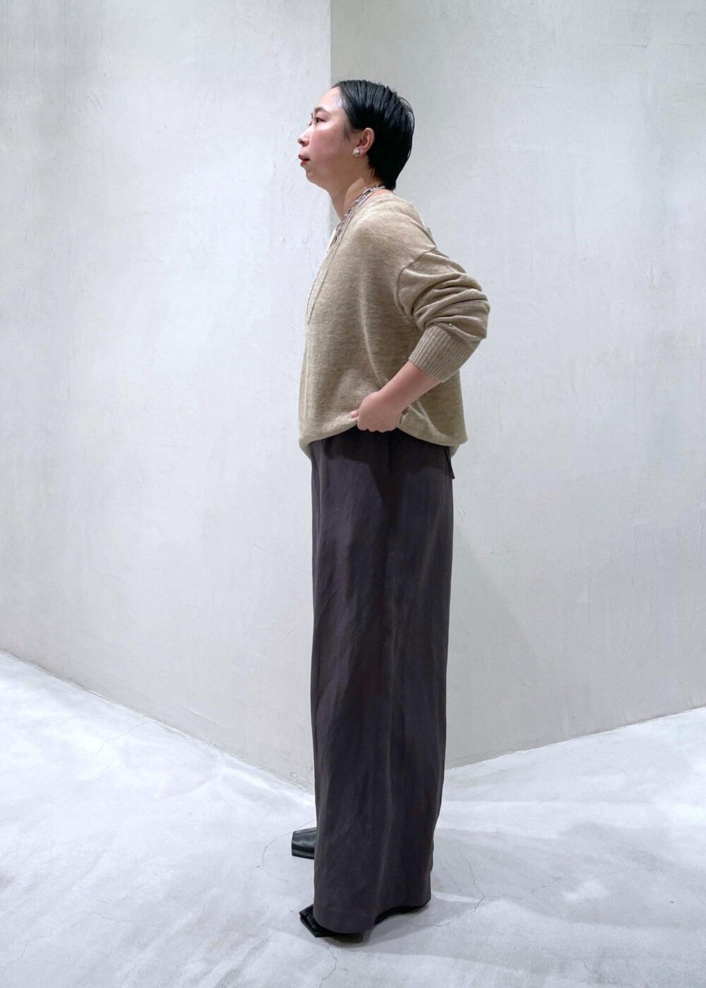 グレー系のつなぎ/オールインワン、ベージュ系のニット/セーターを着用したレディースの春コーディネートの3枚目の写真