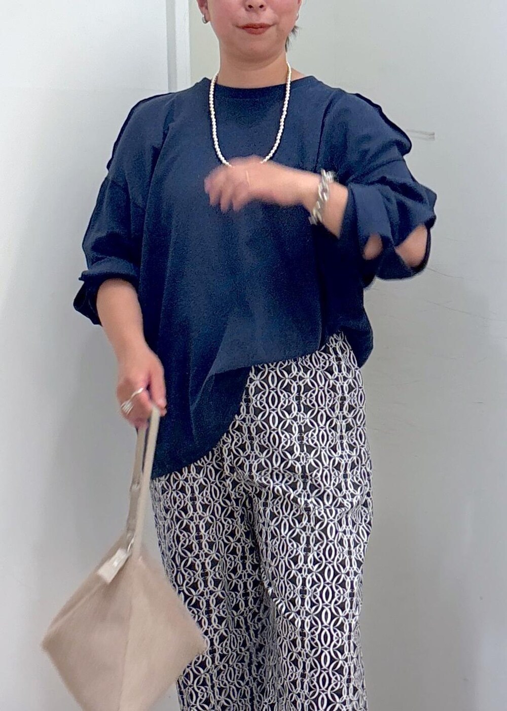 ブラック系のその他パンツ、ベージュ系のショルダーバッグ、グリーン系のパンプスを着用したレディースの夏コーディネートの6枚目の写真
