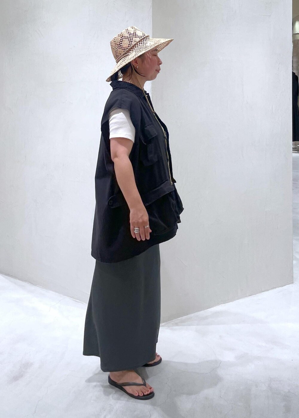 ブラック系のサンダル、ブラック系のベスト、ホワイト系のTシャツ/カットソーを着用したレディースの夏コーディネートの4枚目の写真