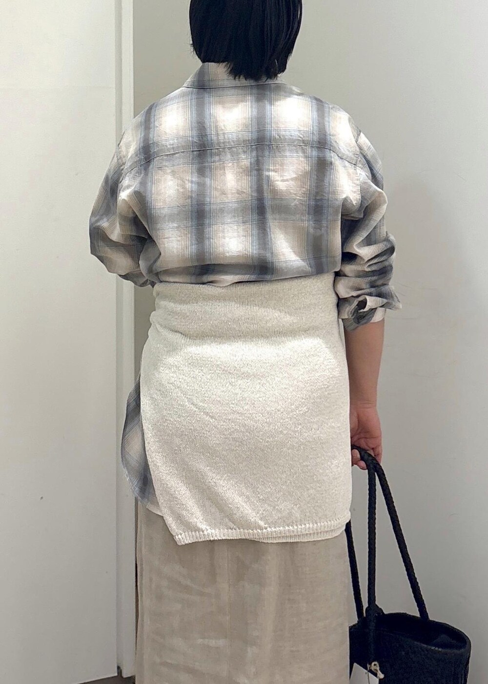 ブラック系のトートバッグ、ベージュ系のスカート、グリーン系のシャツ/ブラウスを着用したレディースの春コーディネートの8枚目の写真