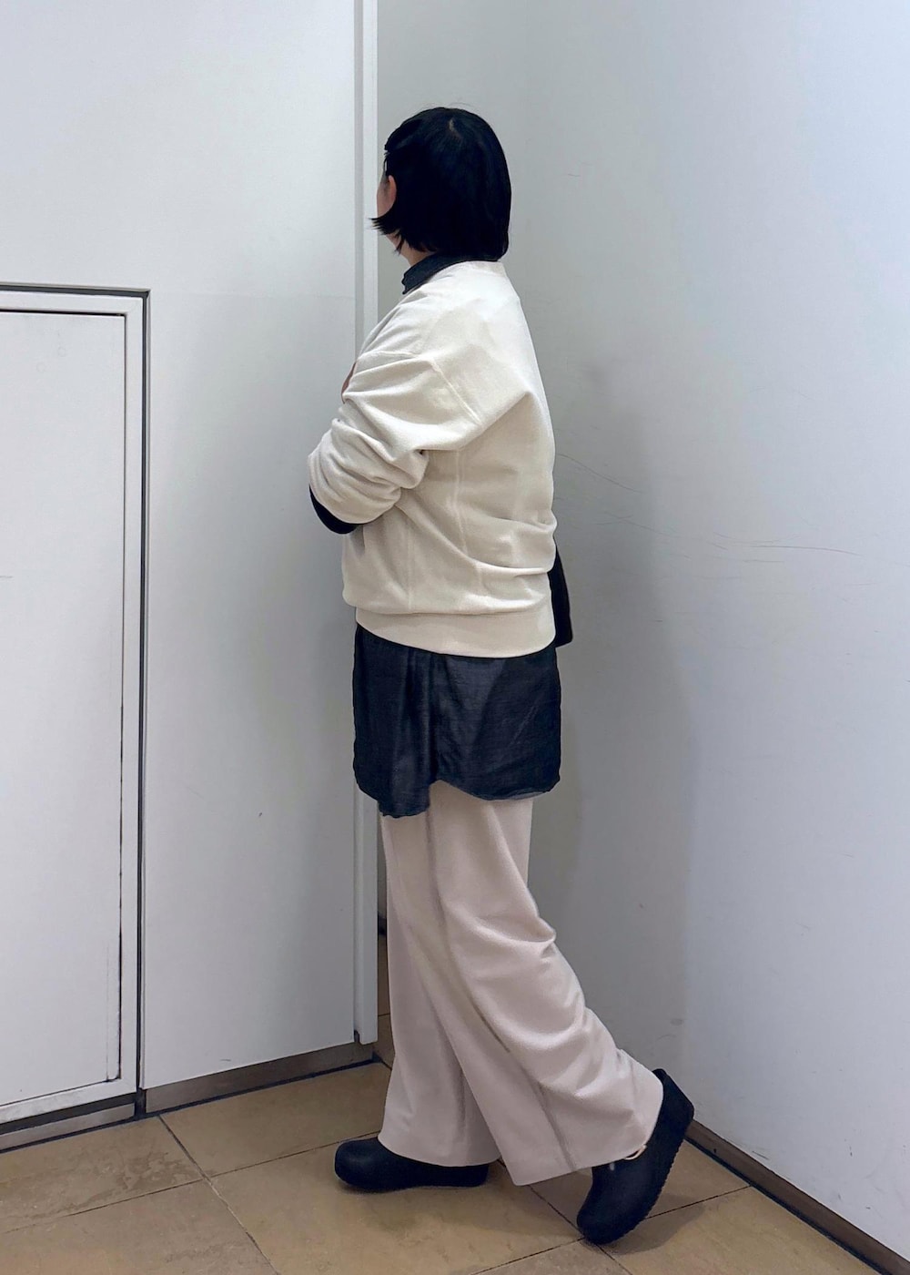 ブラック系のTシャツ/カットソー、ホワイト系のスウェット、ブラック系のトートバッグを着用したレディースの冬コーディネートの7枚目の写真