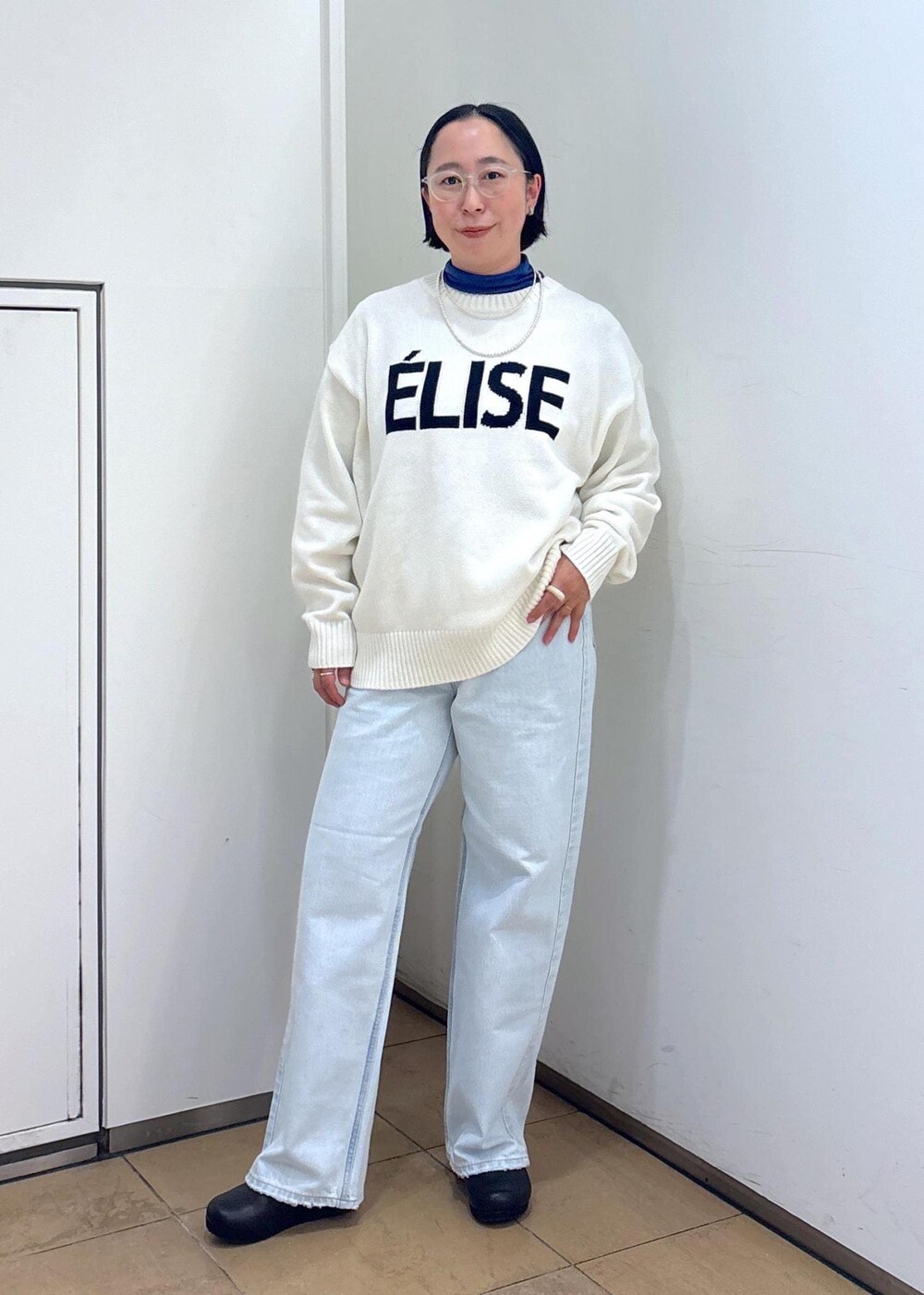 ホワイト系のニット/セーター、シルバー系のショルダーバッグ、ブルー系のデニムパンツを着用したレディースの冬コーディネートの6枚目の写真