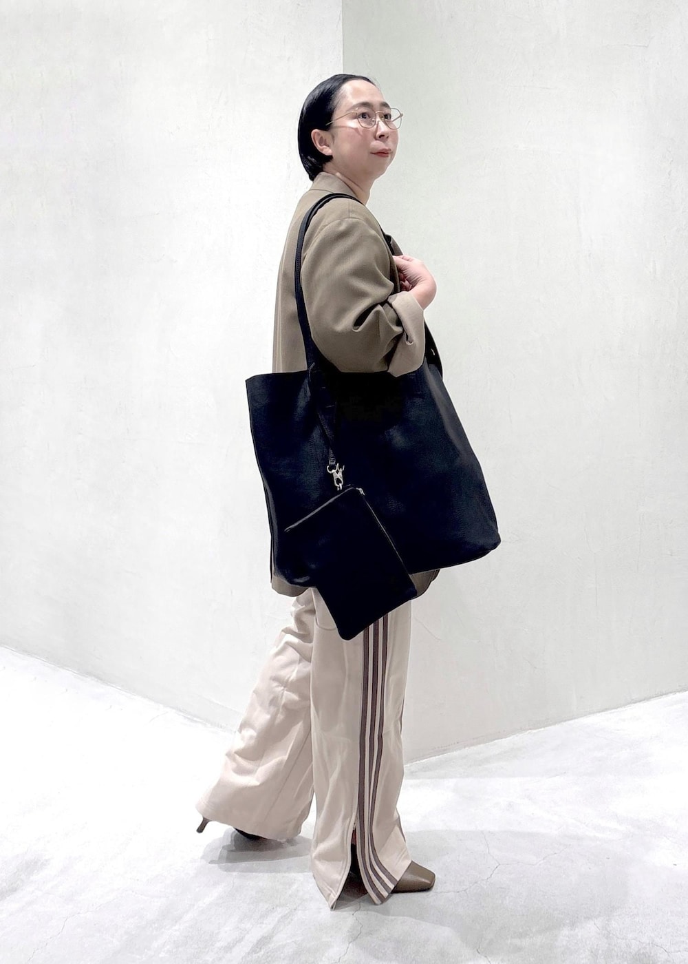 ブラウン系のパンプス、ホワイト系のTシャツ/カットソー、ベージュ系のその他パンツを着用したレディースの冬コーディネートの7枚目の写真