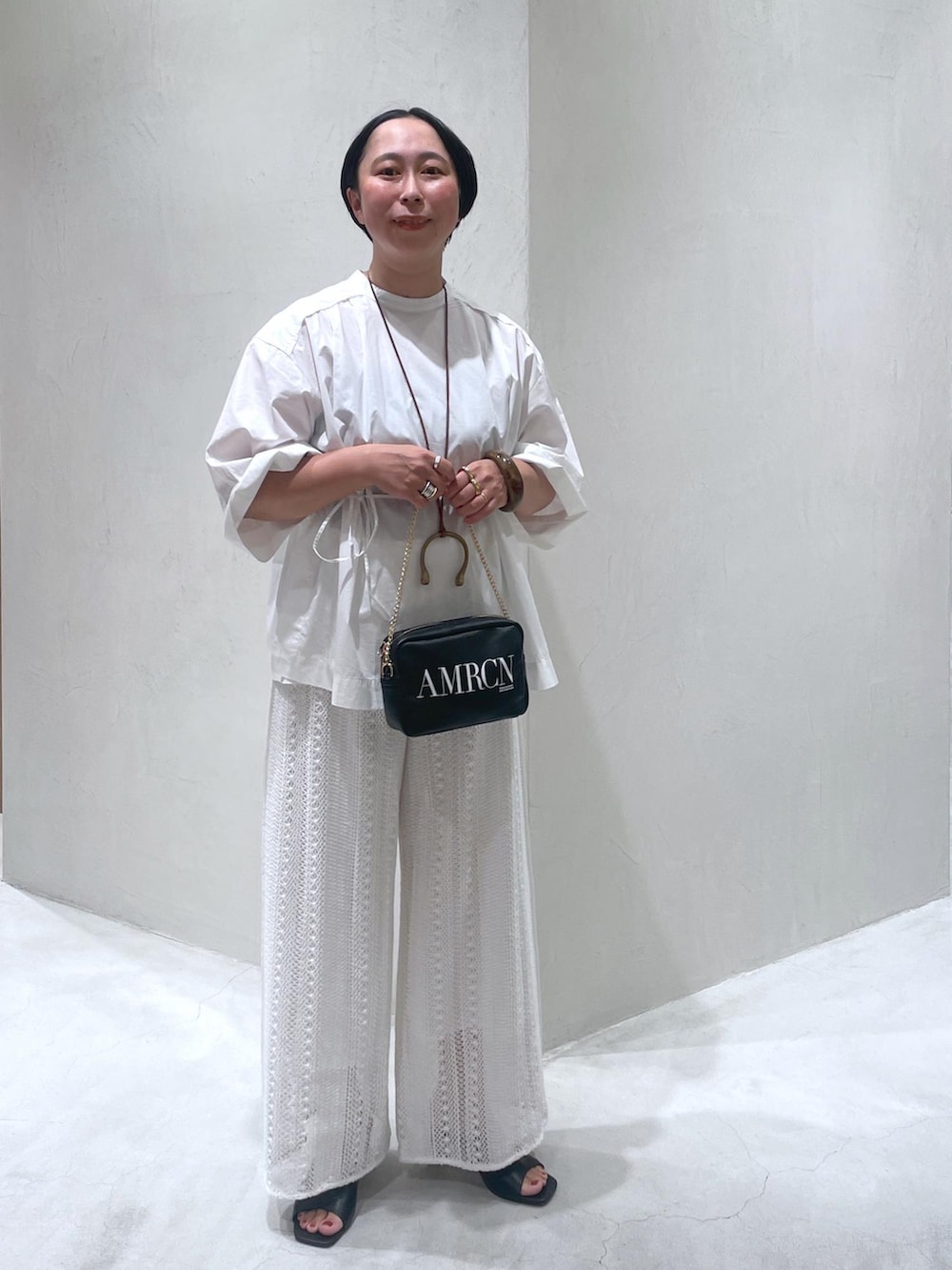 ブラック系のトートバッグ、ホワイト系のその他パンツ、ブラック系のサンダルを着用したレディースの夏コーディネートの2枚目の写真
