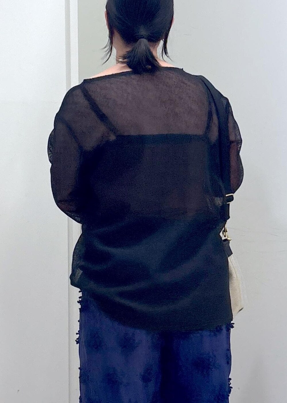 ブラック系のニット/セーター、ブルー系のその他パンツ、ホワイト系のショルダーバッグを着用したレディースの夏コーディネートの9枚目の写真